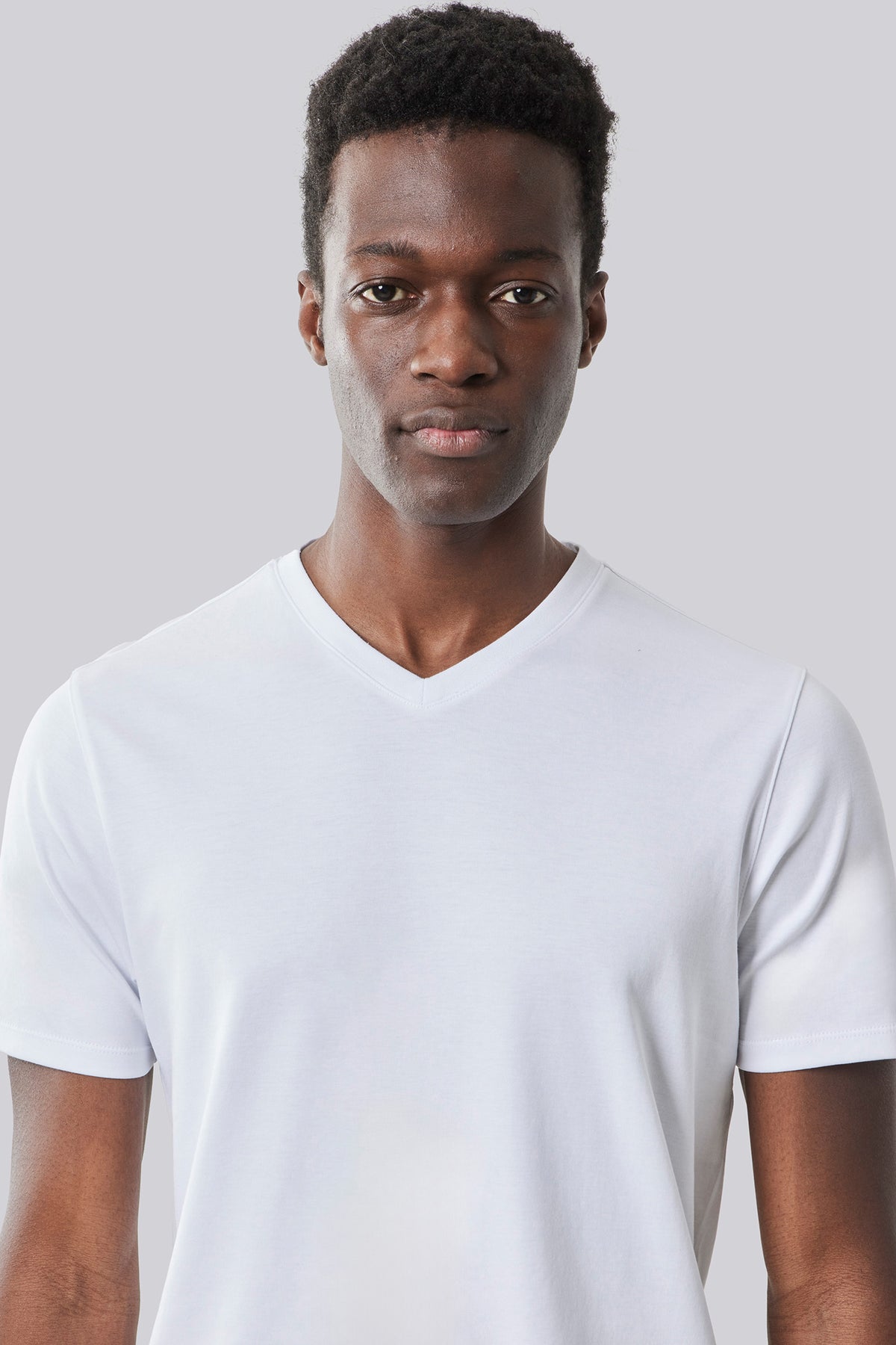 White V-neck t-shirt with short sleeves on a model against a neutral background.