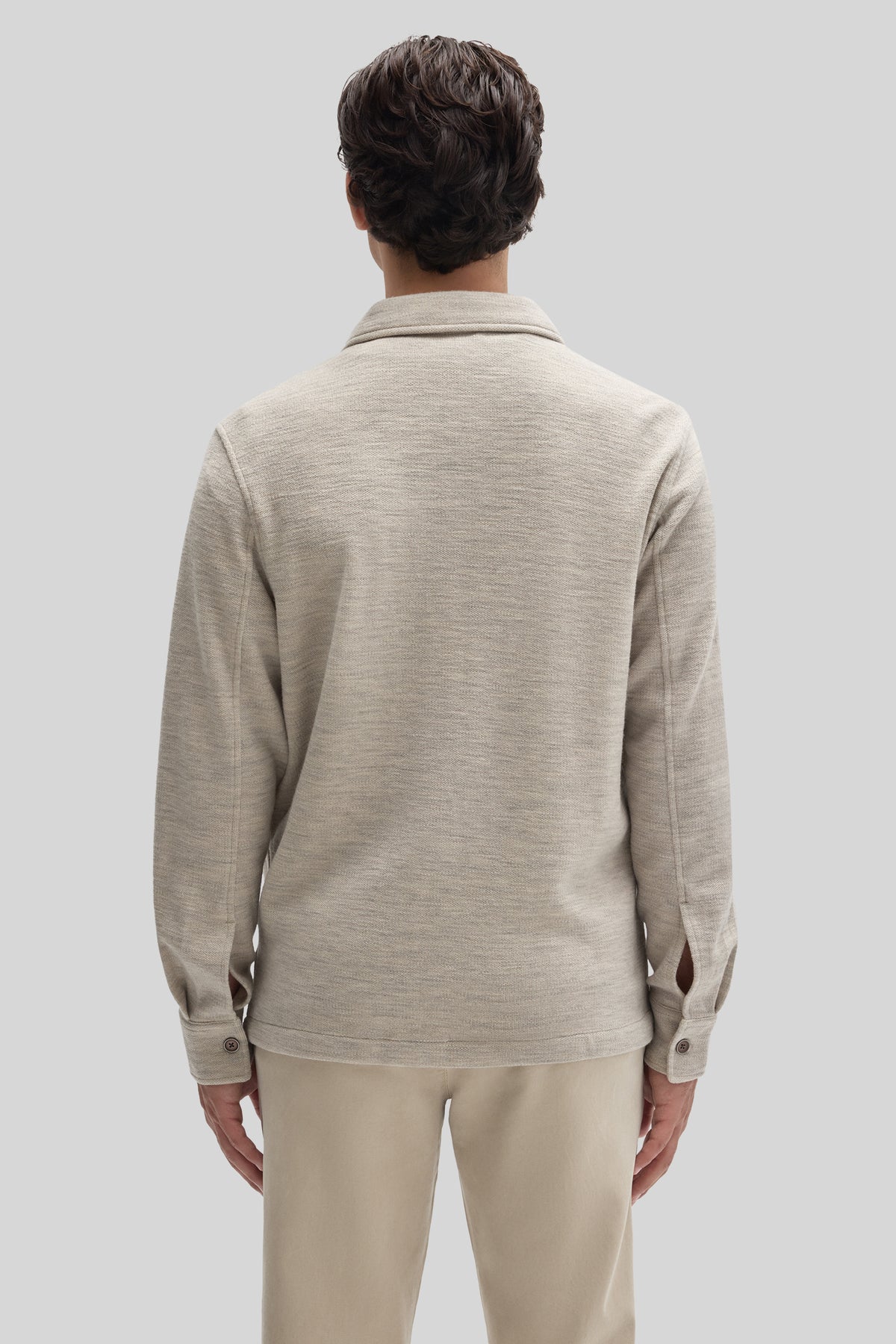 Beige overshirt with textured fabric, collar, and button cuffs, shown from back view on model.