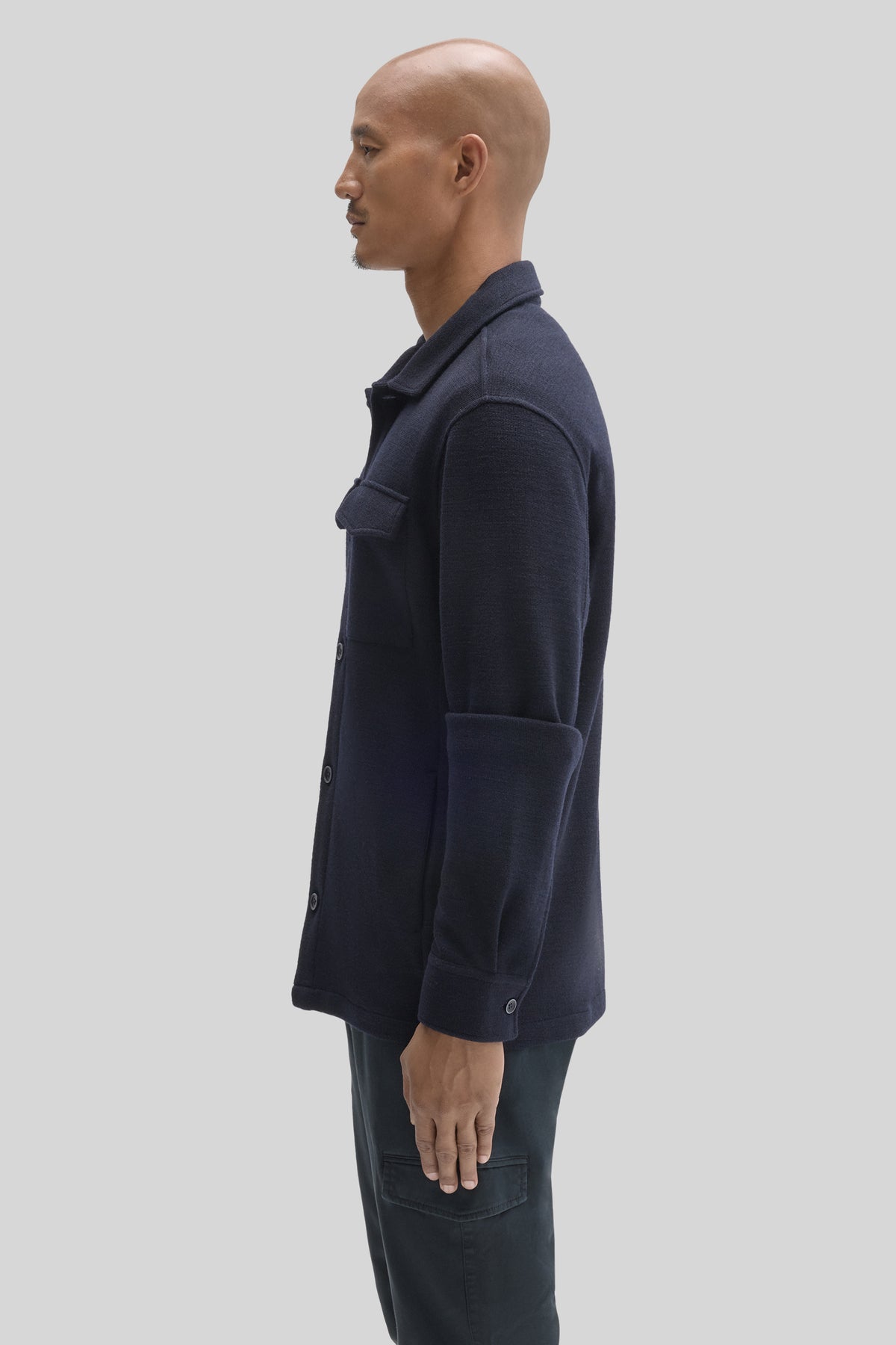 Navy blue overshirt with spread collar, button front, and chest pocket worn by model in side profile.