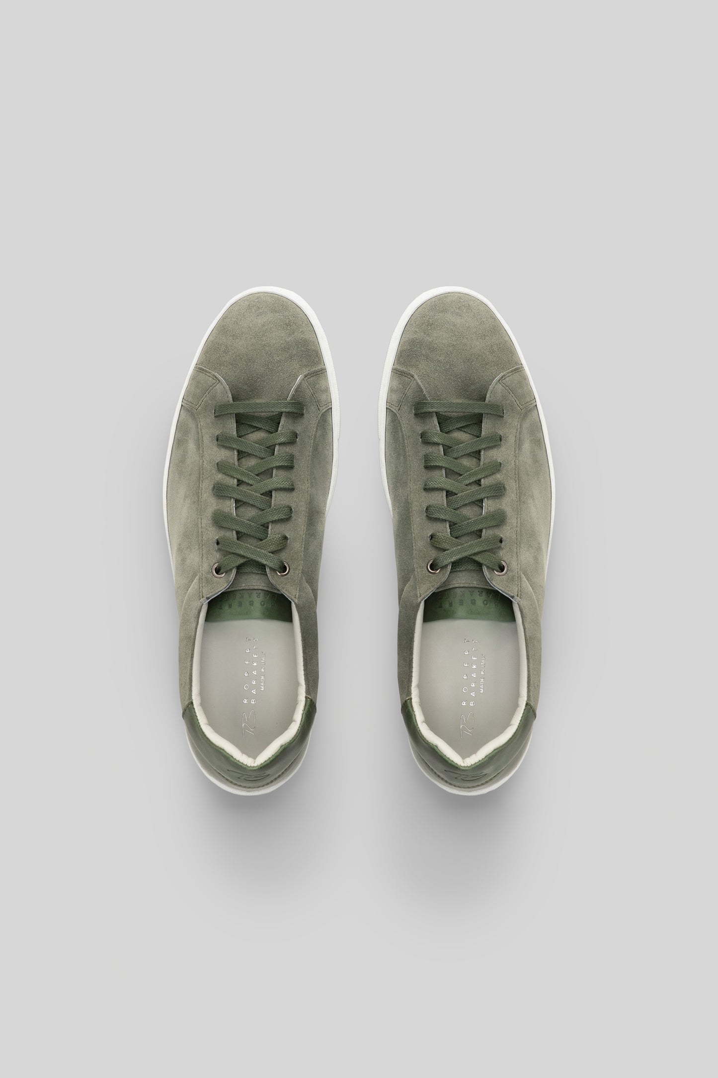 Sage green suede sneakers with white rubber sole and lace-up closure, shown from top view.