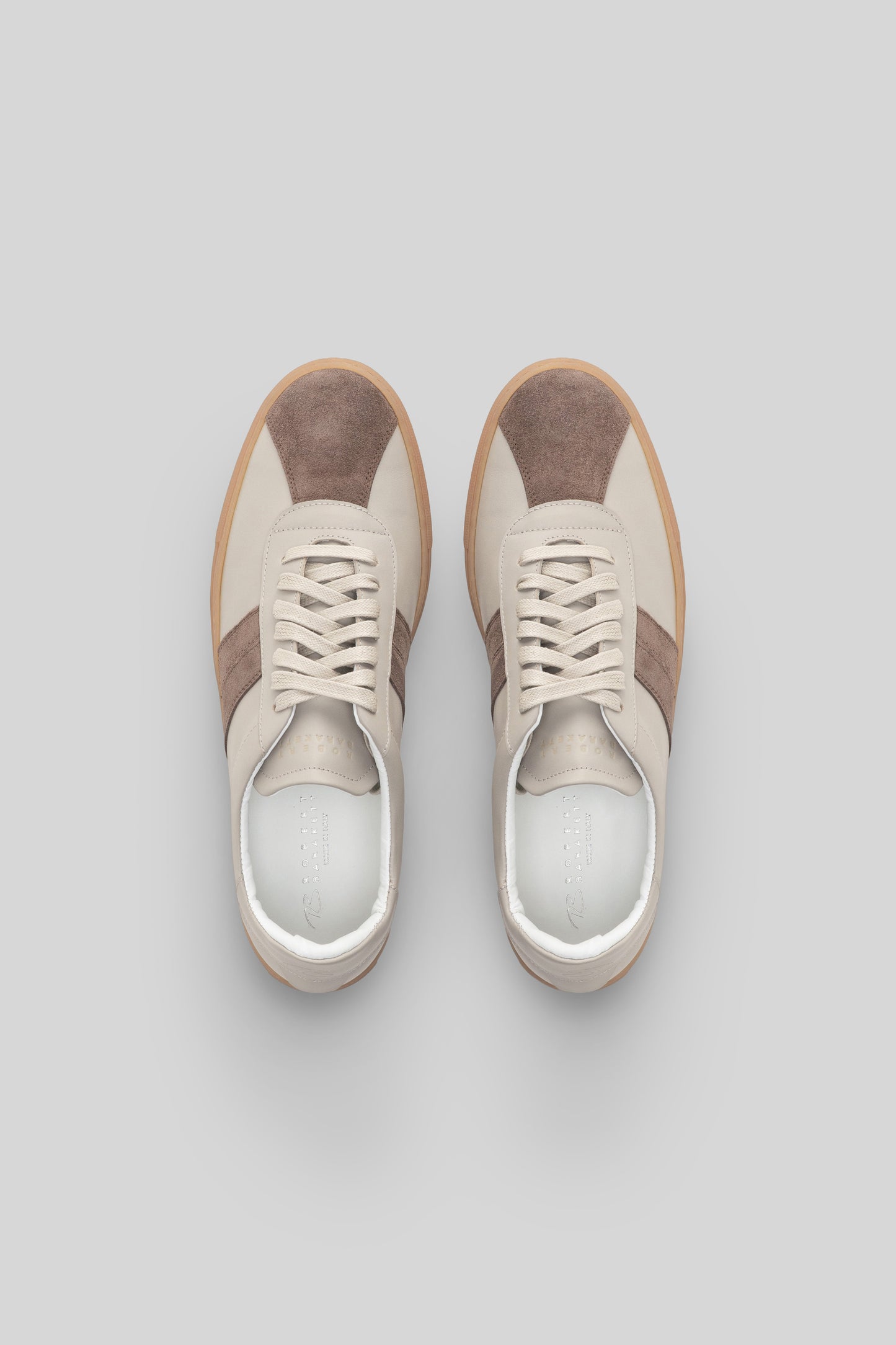 Pair of cream and taupe striped sneakers with lace-up closure and gum sole, viewed from above.