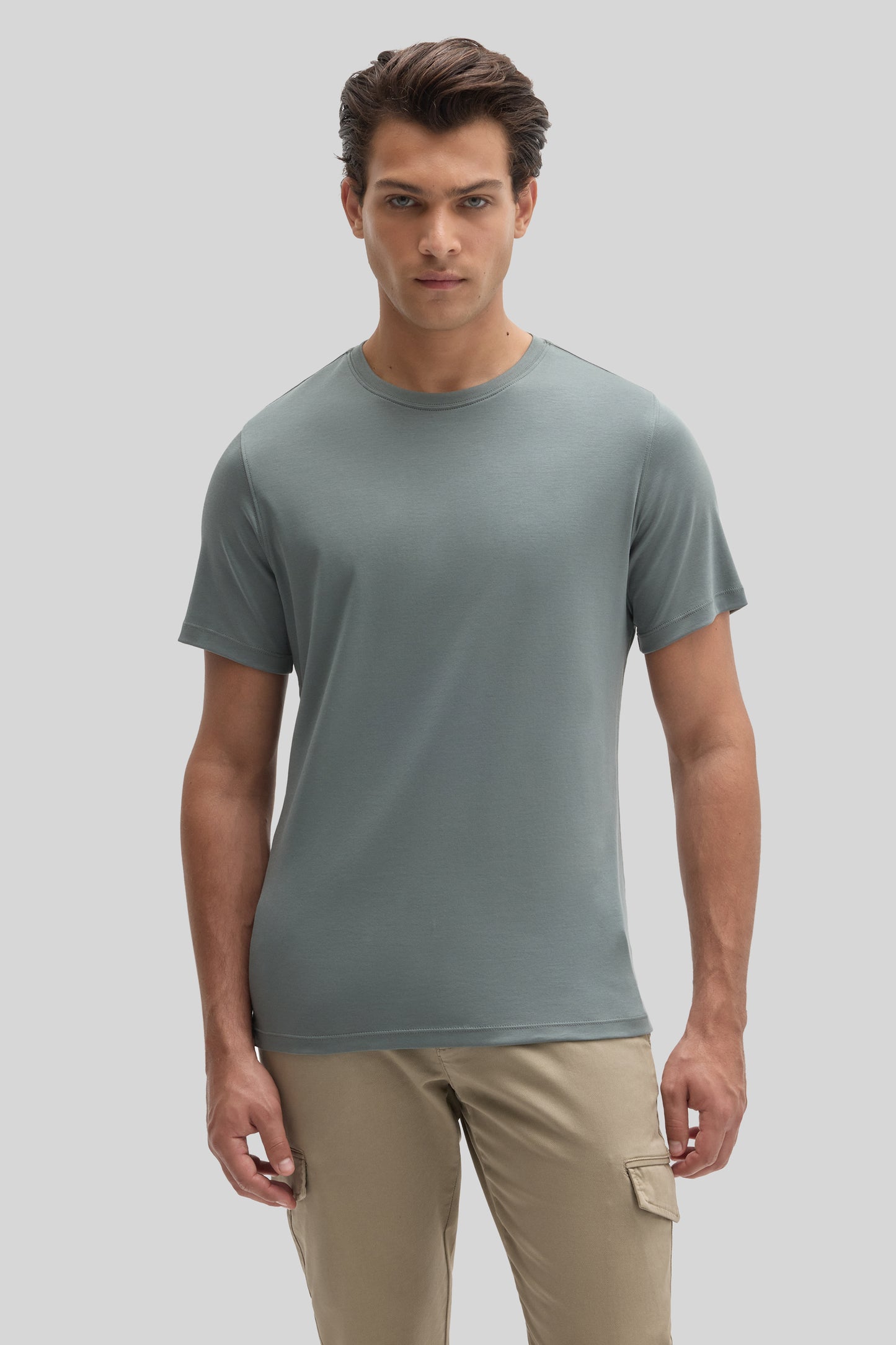 Man wearing sage green crew-neck t-shirt with short sleeves and khaki cargo pants.