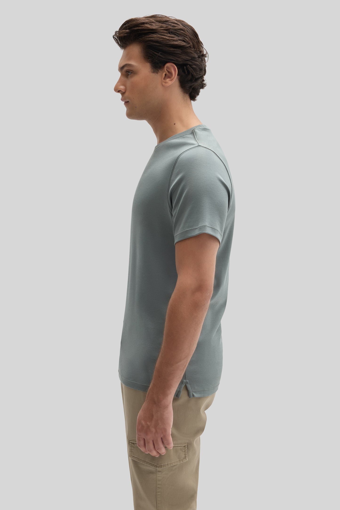 Man wearing light gray short-sleeve t-shirt with tan cargo pants, shown in side profile.