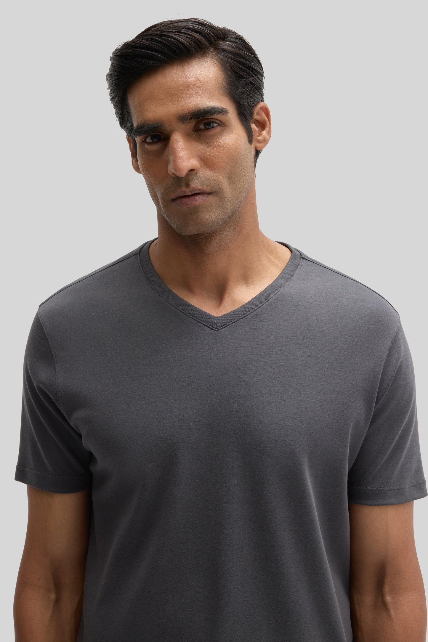 Man wearing a charcoal gray V-neck short-sleeve t-shirt.