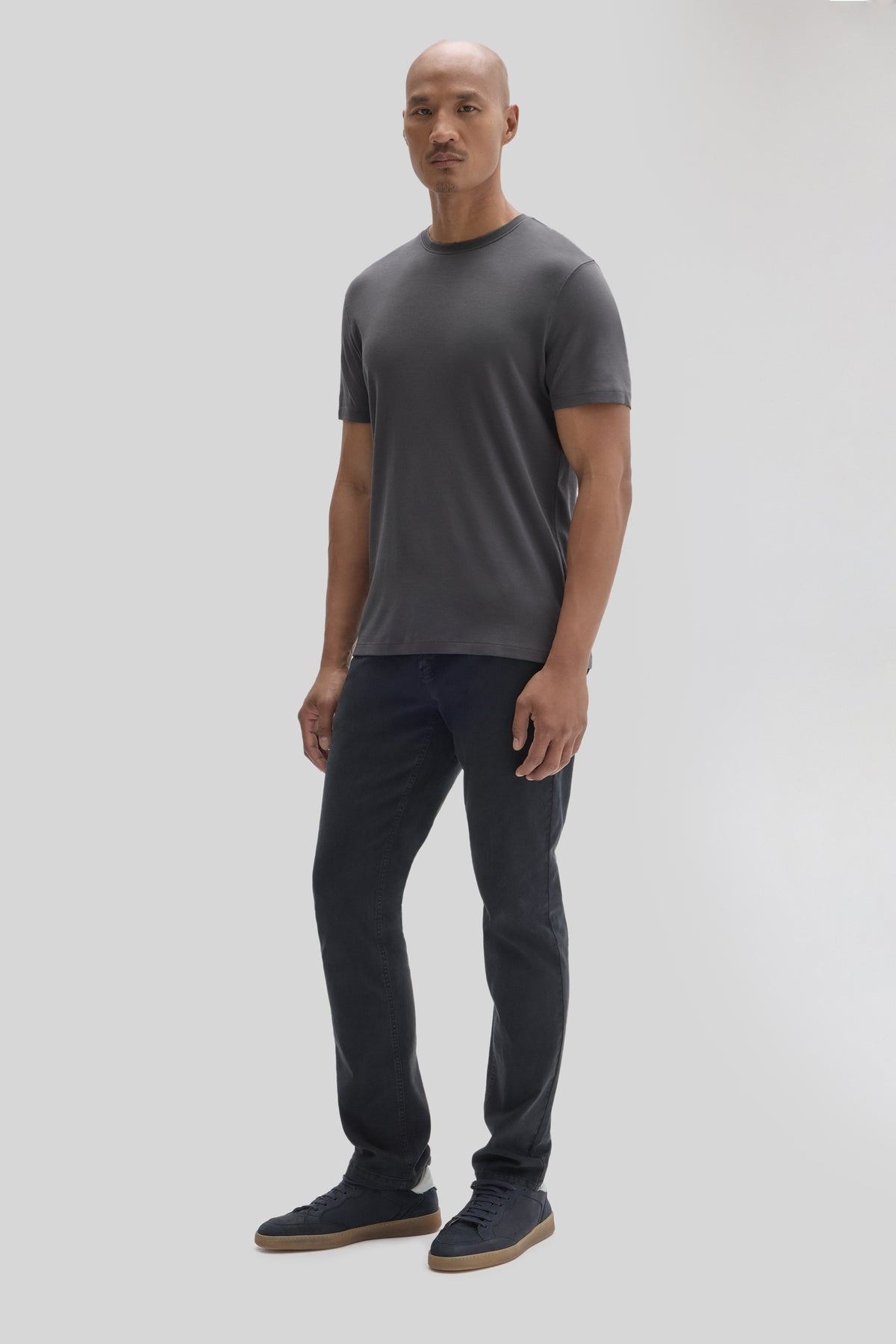 Man wearing charcoal gray short-sleeve t-shirt with crew neckline and dark denim jeans.
