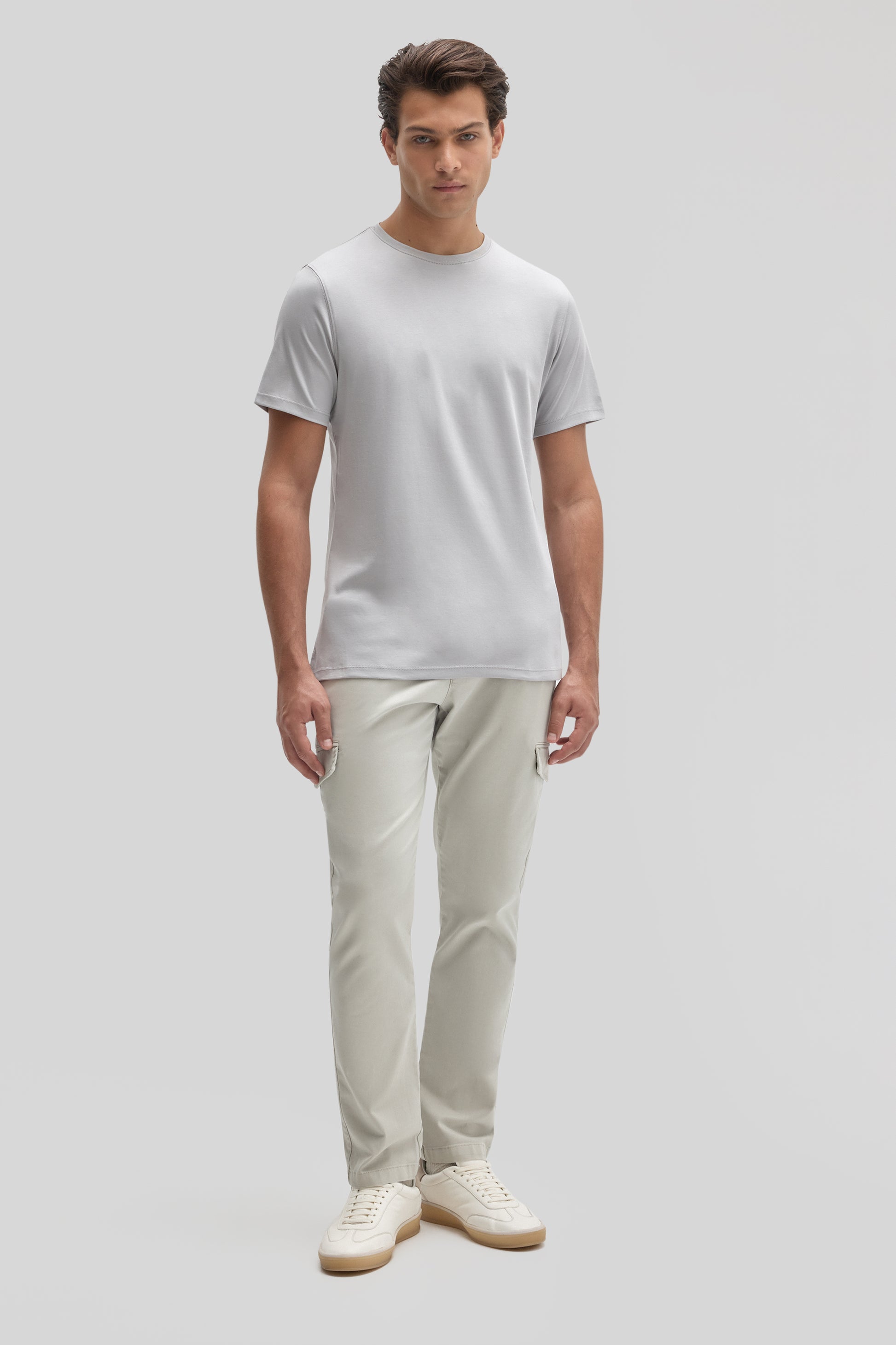 Man wearing white crew neck t-shirt with beige cargo pants and cream canvas sneakers.