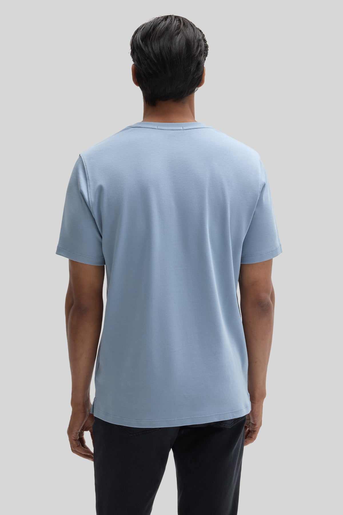 Man wearing light blue short-sleeve crew neck t-shirt, back view.