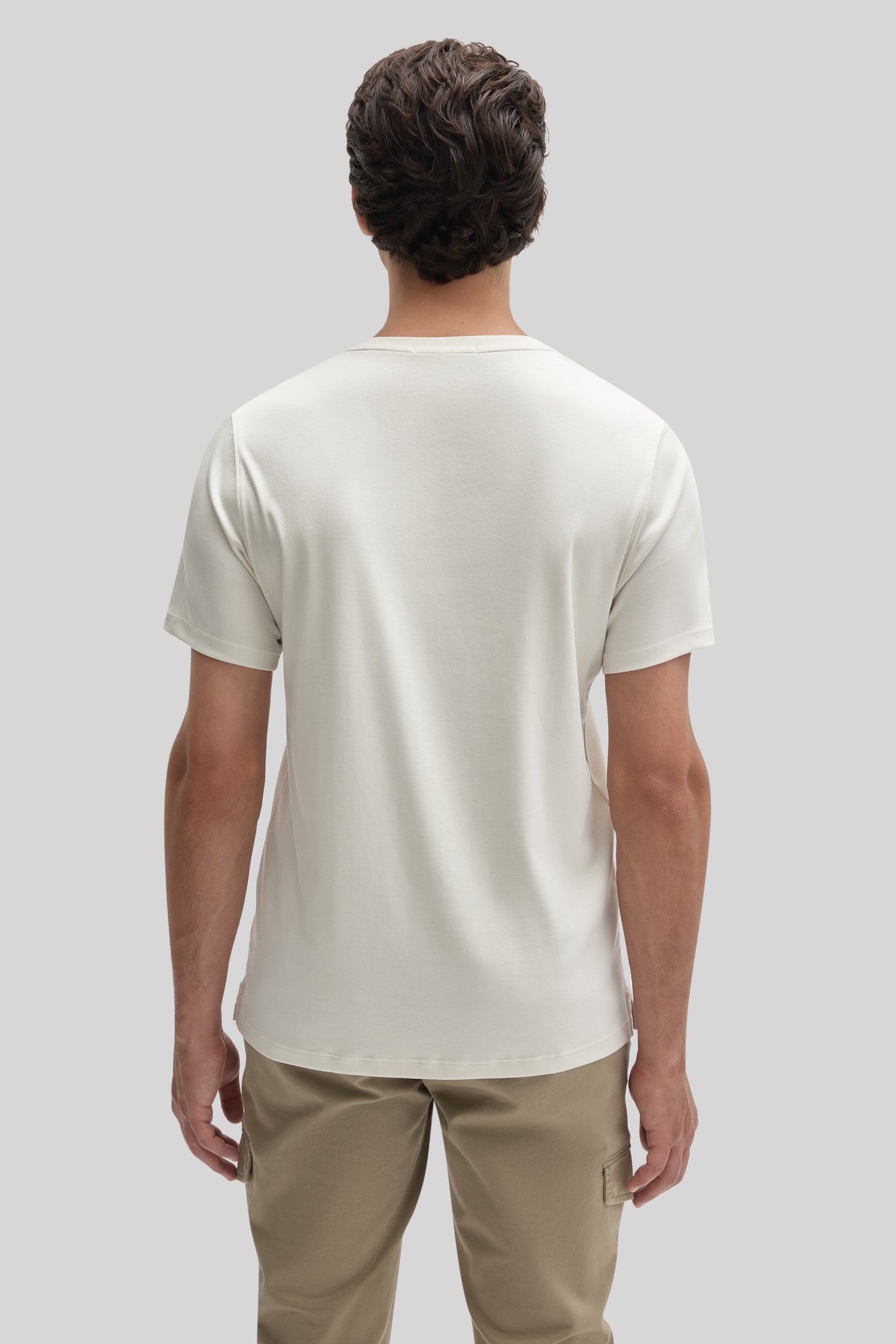 Man wearing cream-colored short-sleeve t-shirt with crew neckline, back view.