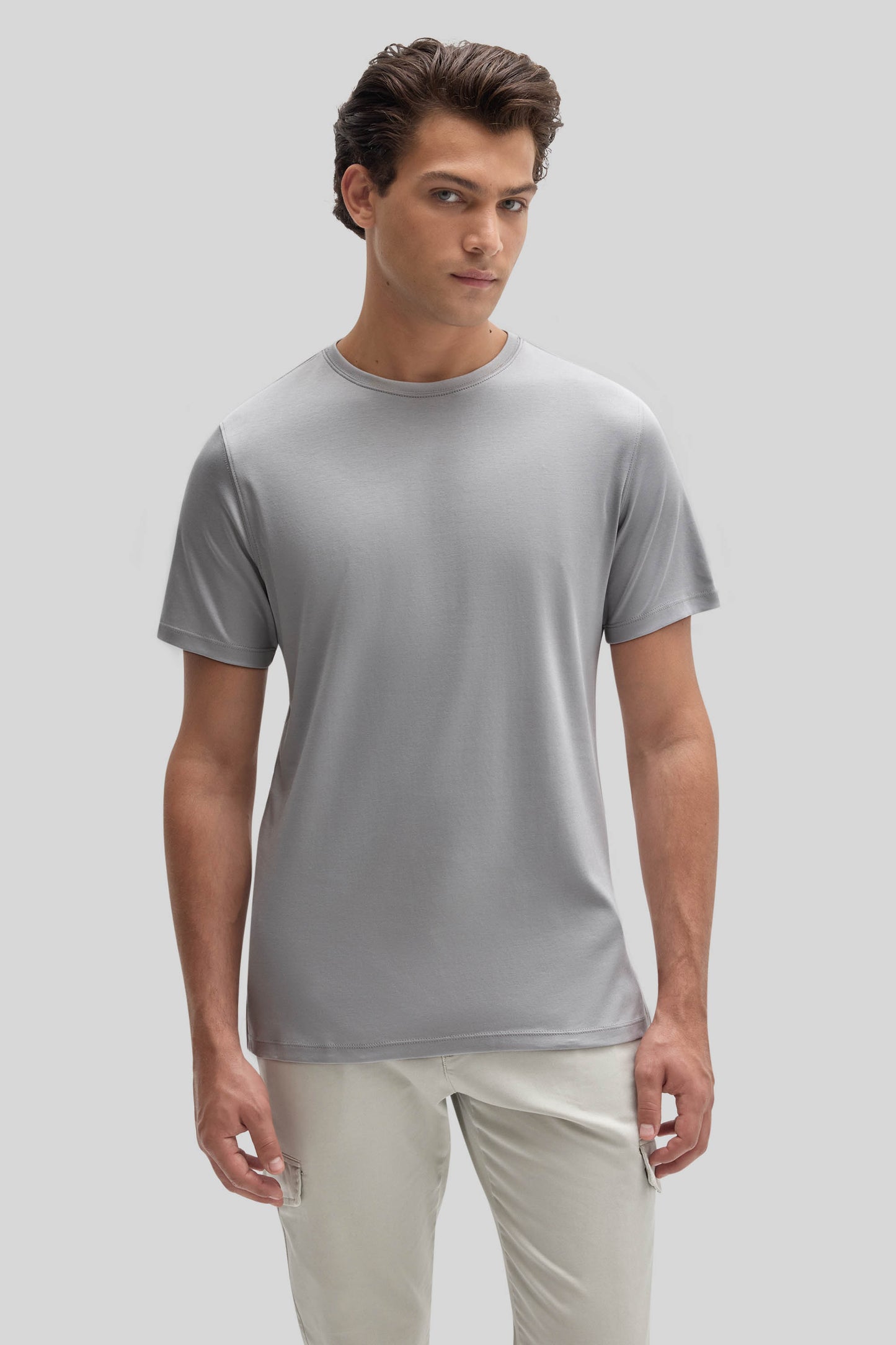 Man wearing light gray crew neck t-shirt with short sleeves and cream-colored pants.