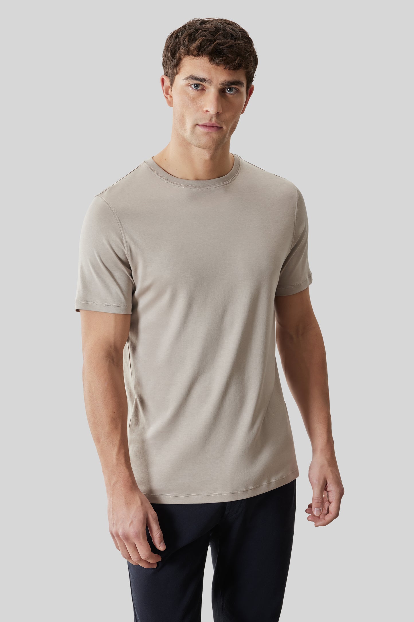 Beige crewneck short-sleeve t-shirt worn with black pants.