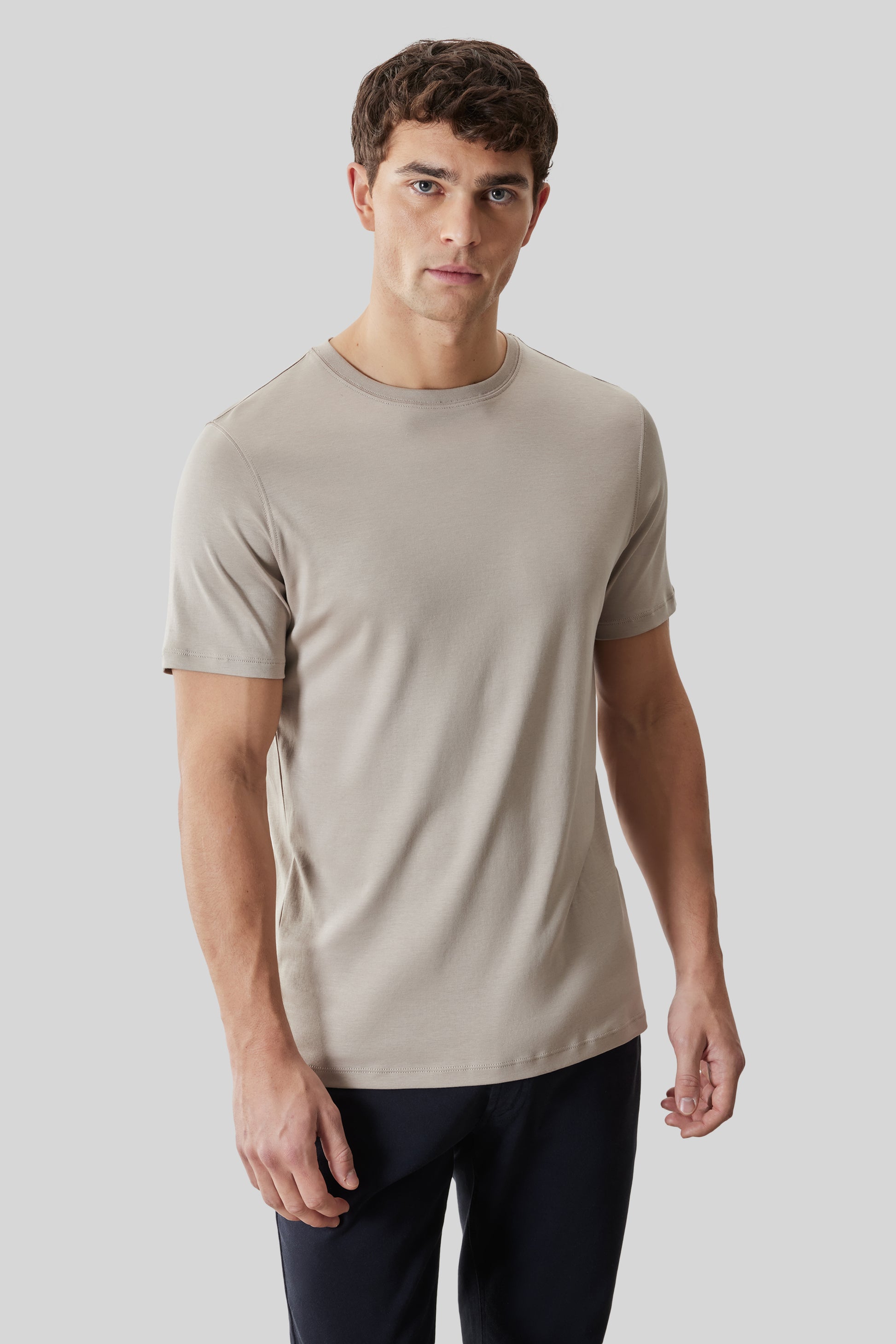Beige crewneck short-sleeve t-shirt worn with black pants.