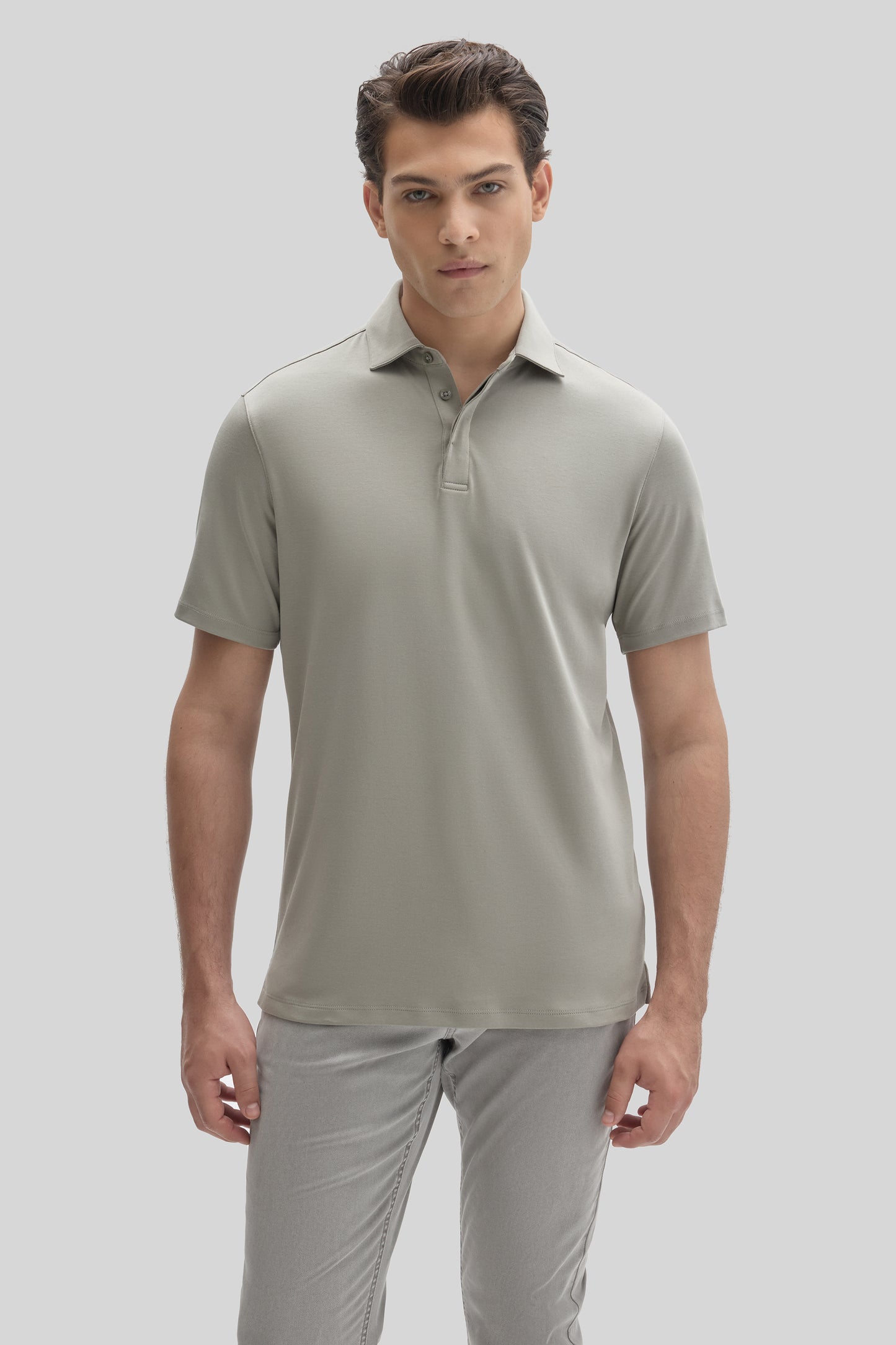 Man wearing a light gray short-sleeve polo shirt with a covered placket and collar.