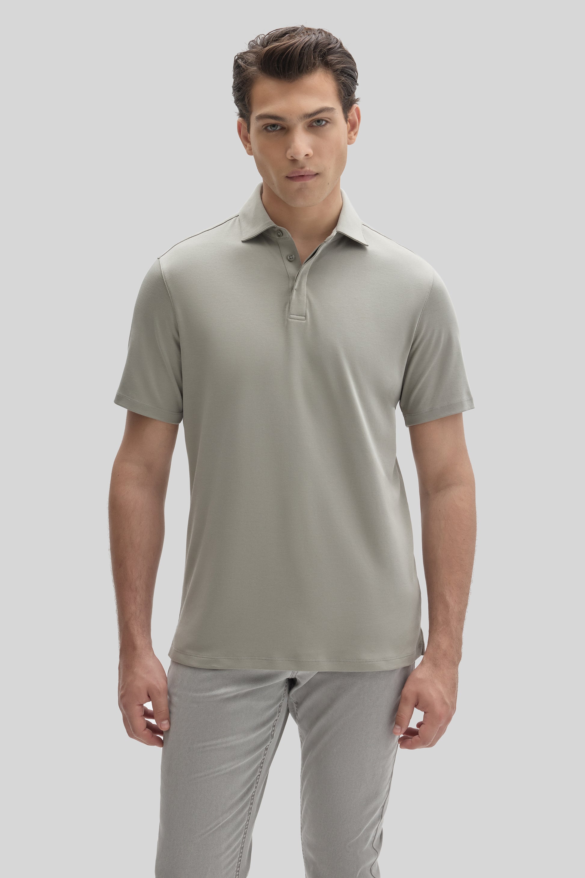 Man wearing a light gray short-sleeve polo shirt with a covered placket and collar.