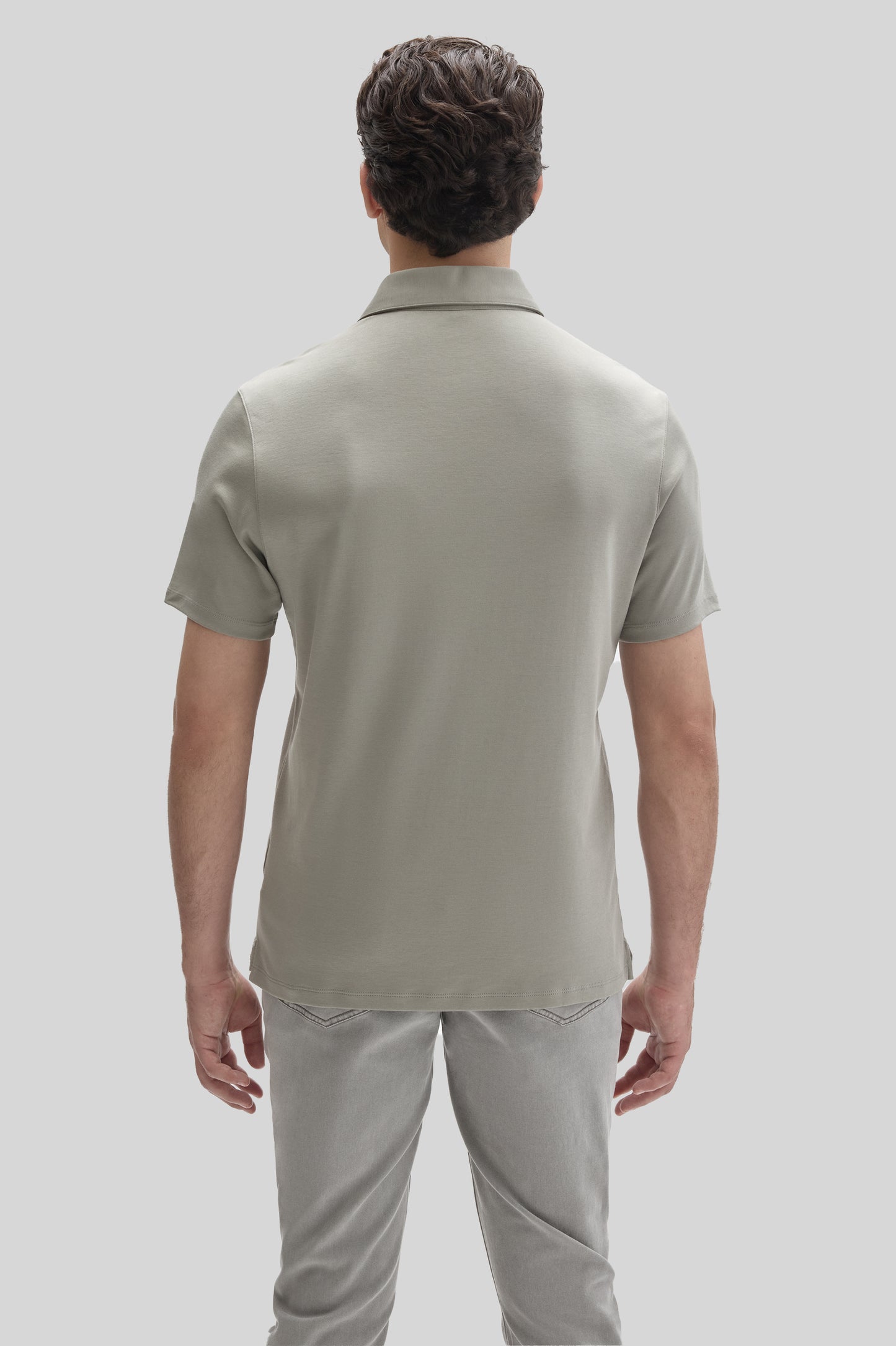 Man wearing a light gray short-sleeve polo shirt with a collared neckline, shown from behind.