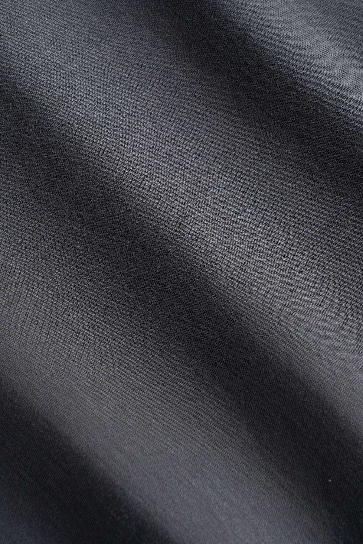 Charcoal gray polo shirt fabric with textured weave and natural draping.
