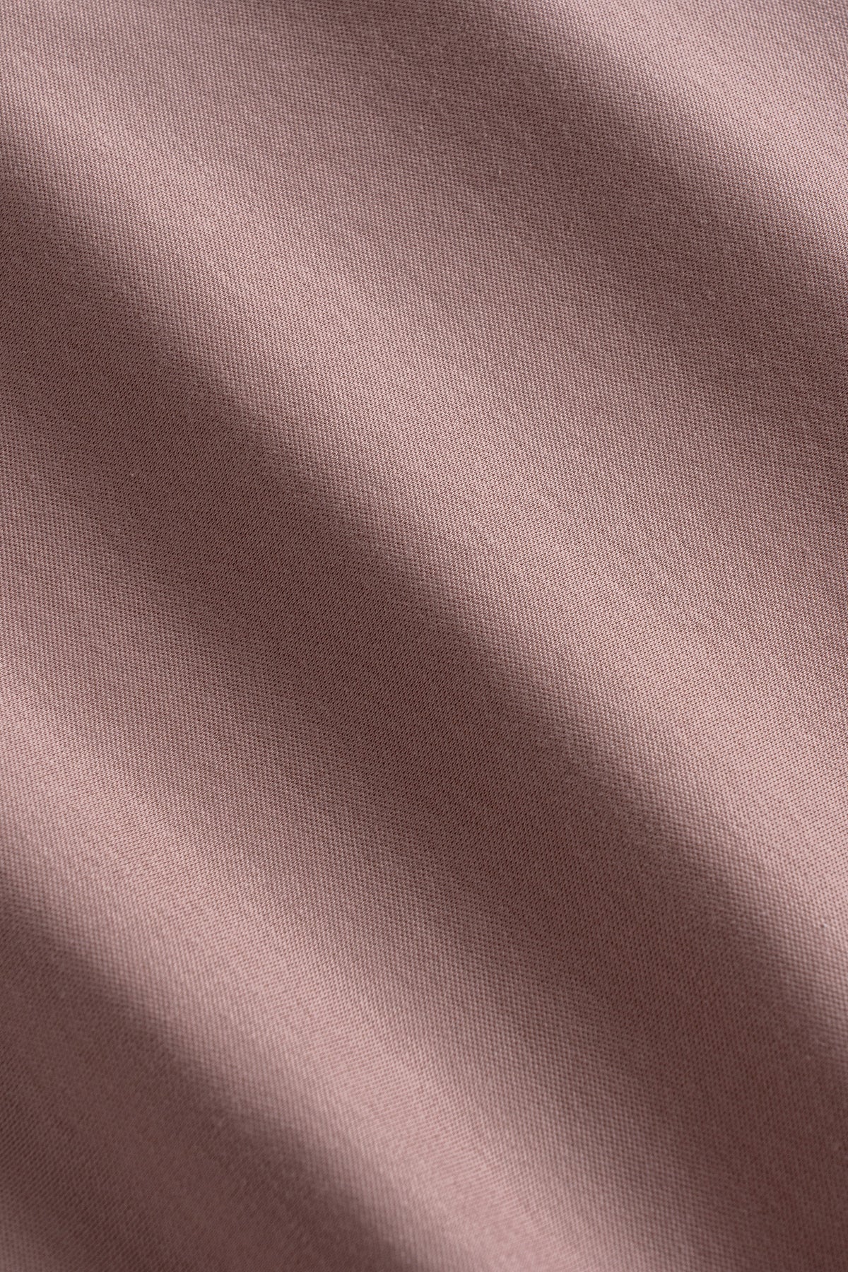 Mauve polo shirt with ribbed knit texture and natural fabric draping visible.