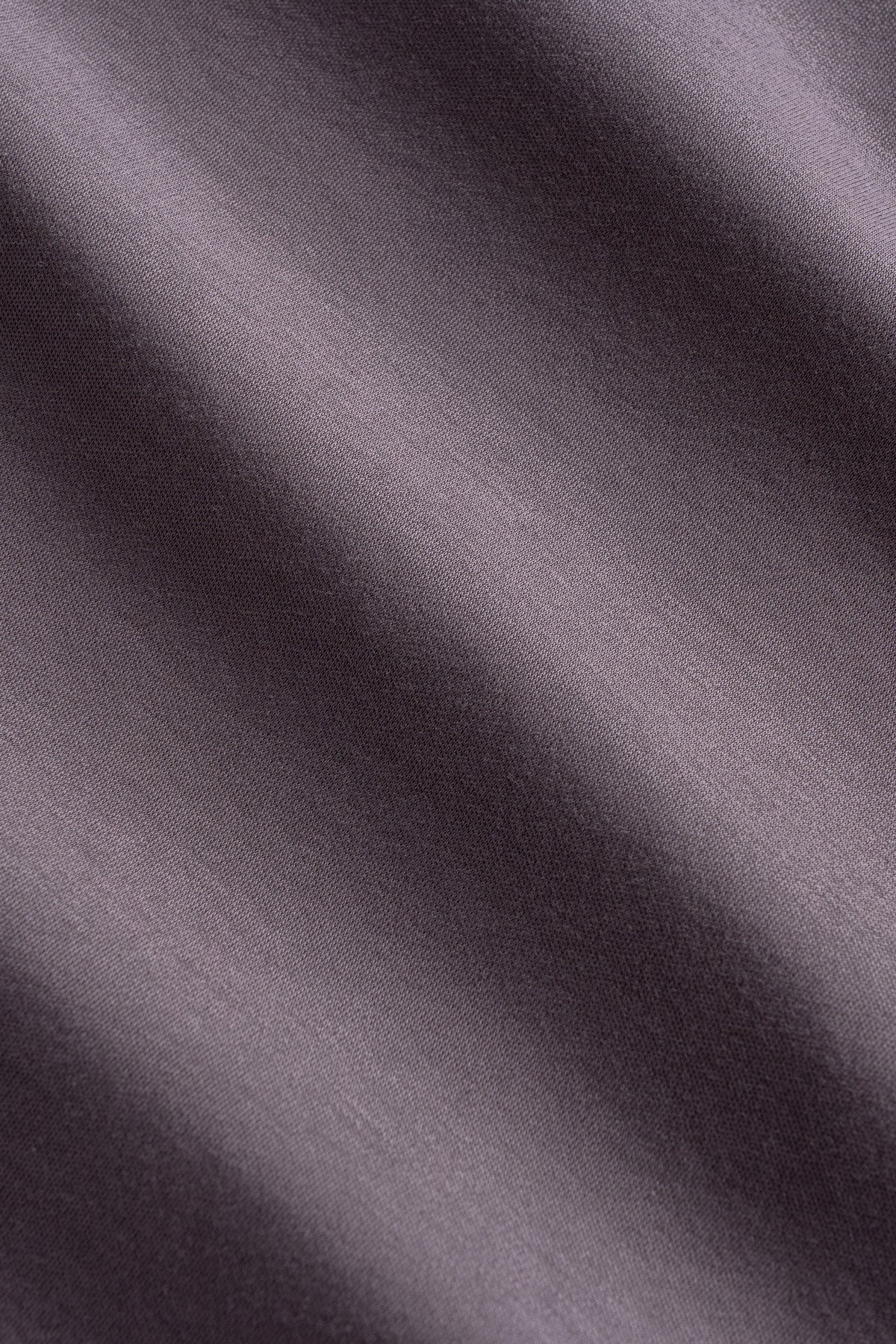 Gray ribbed knit fabric with diagonal texture and natural fold shadows.