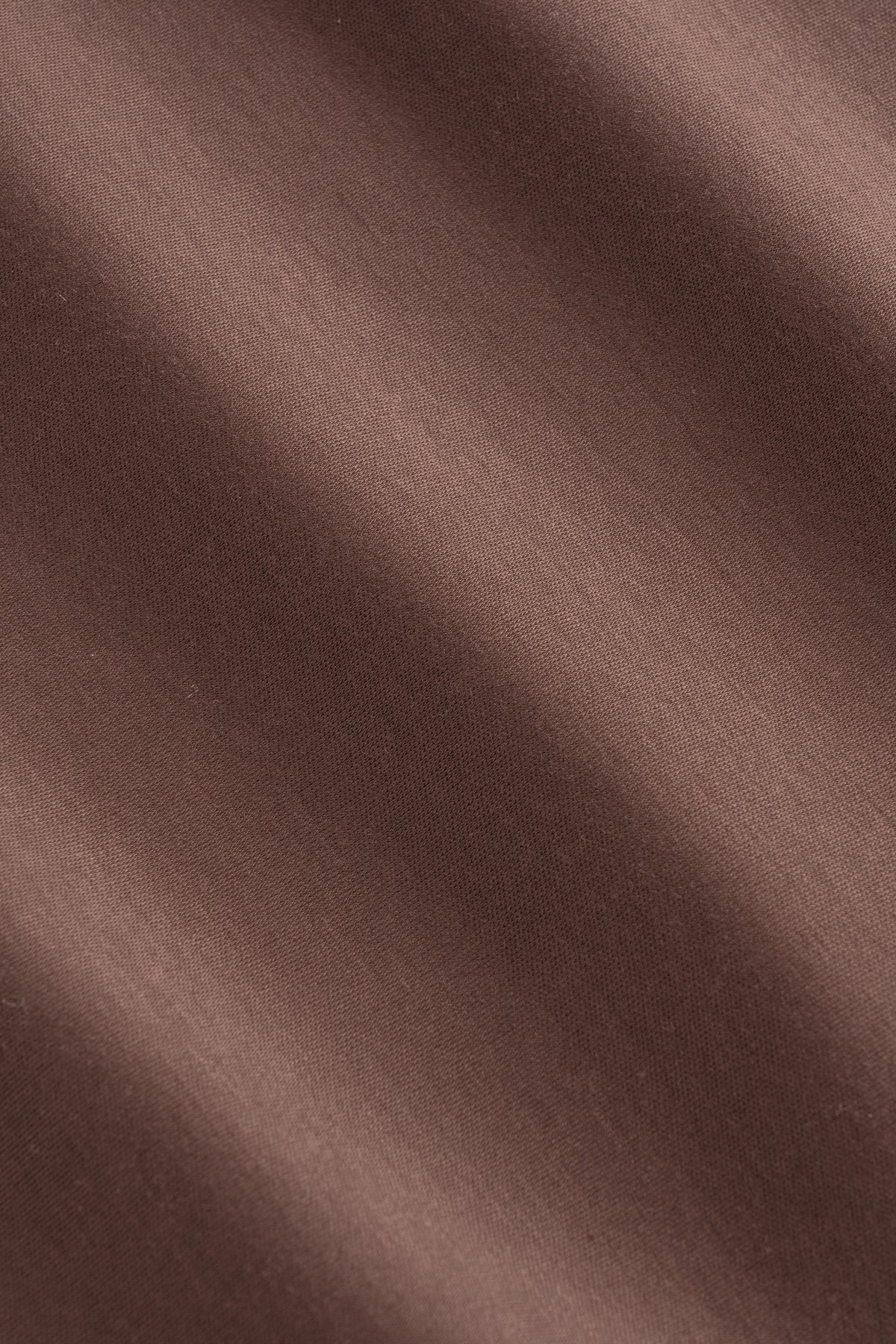 Brown knit fabric texture with ribbed weave pattern and subtle fold details.