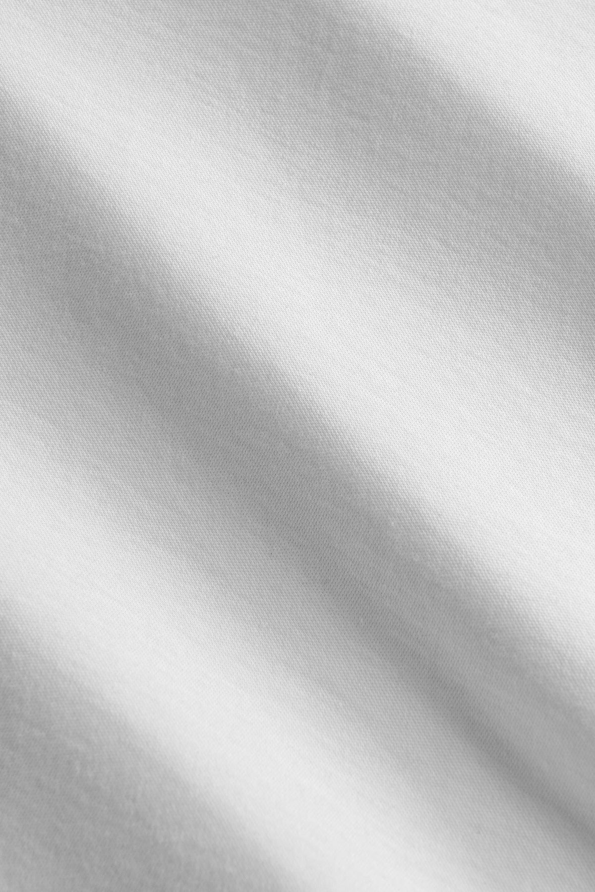 White polo shirt with textured fabric and short sleeves, displayed on a flat surface.