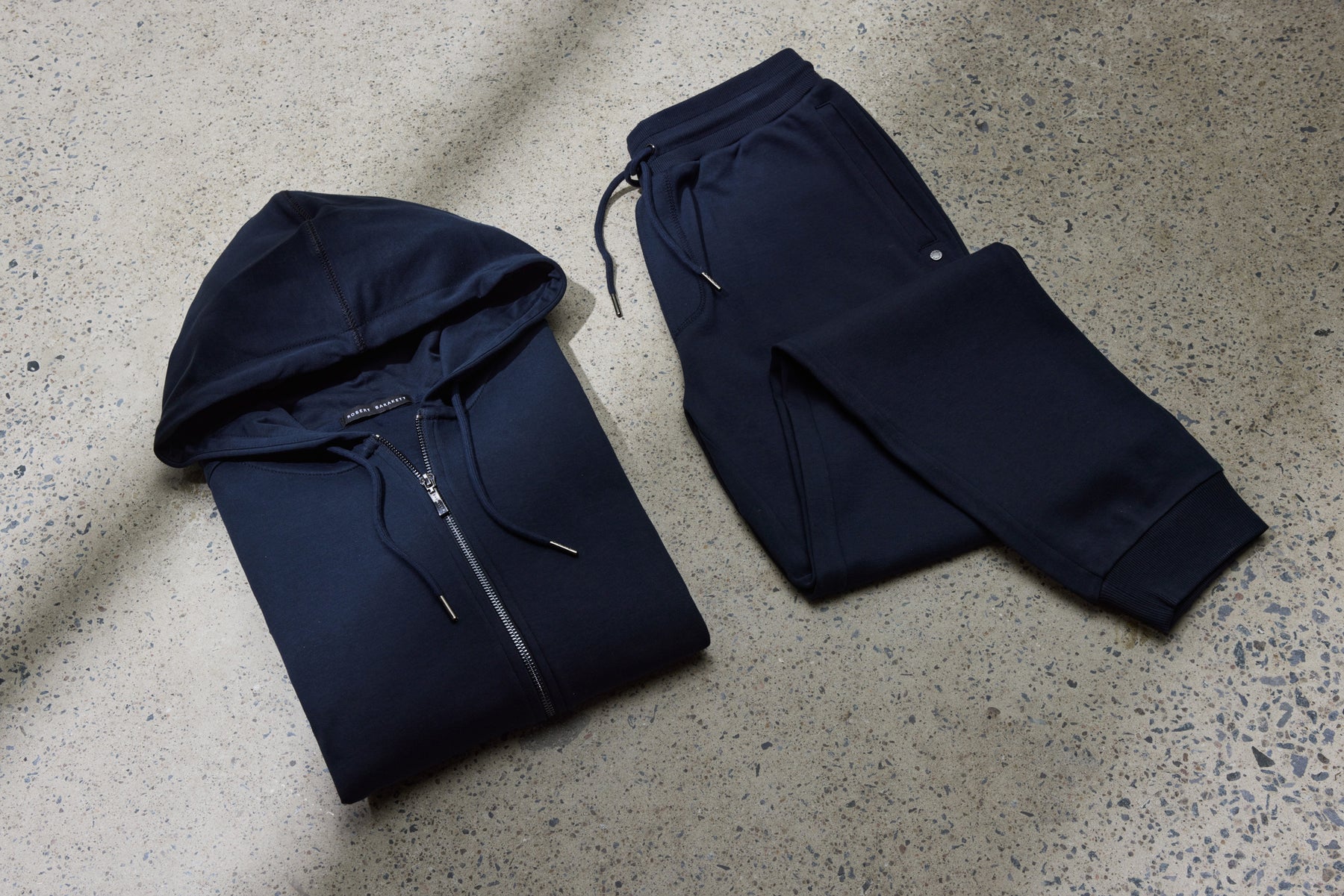 a navy blue hoodie and jogger pants laying flat and folded