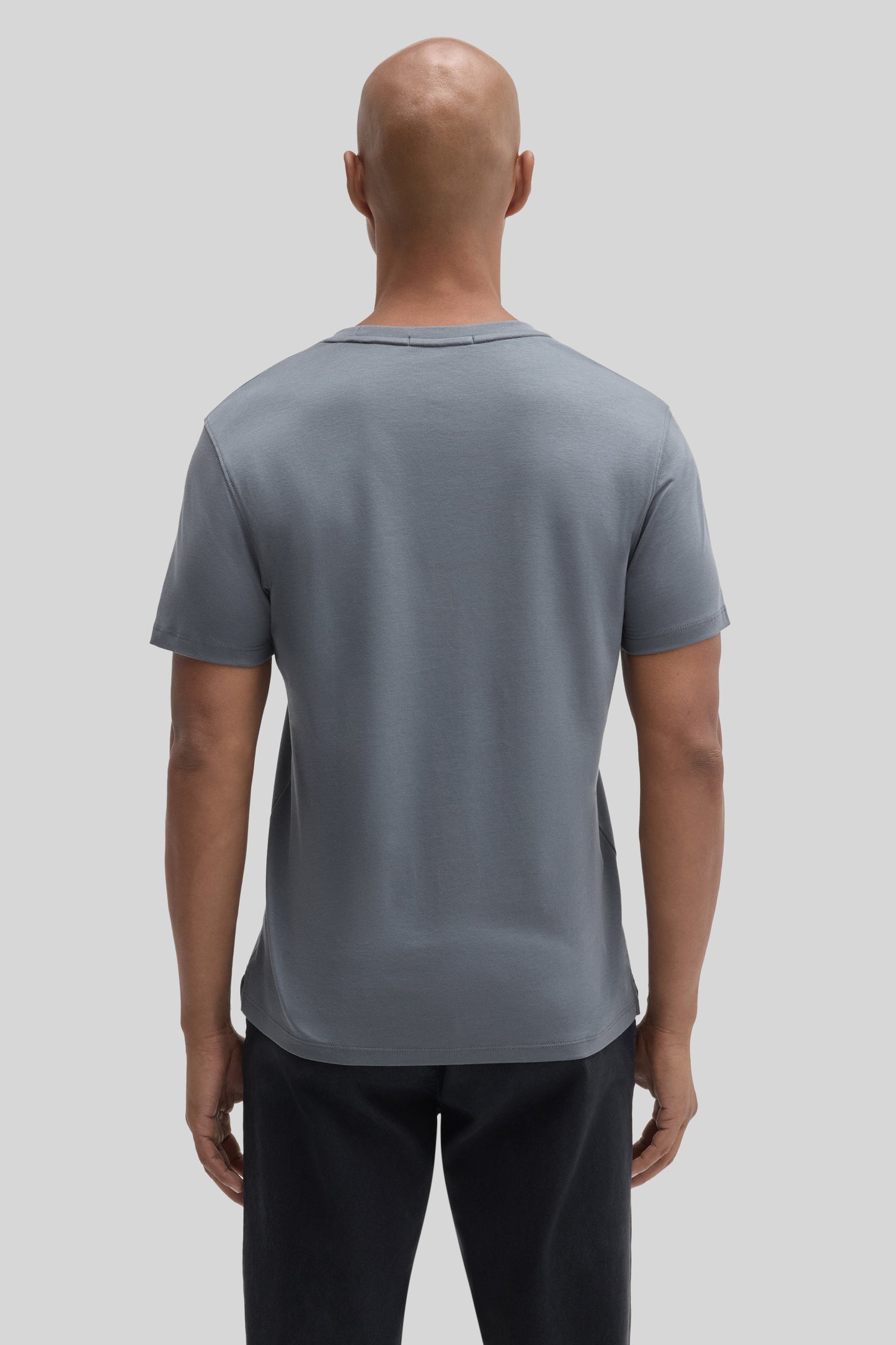 Man wearing slate blue short-sleeved t-shirt with crew neckline, shown from back view.