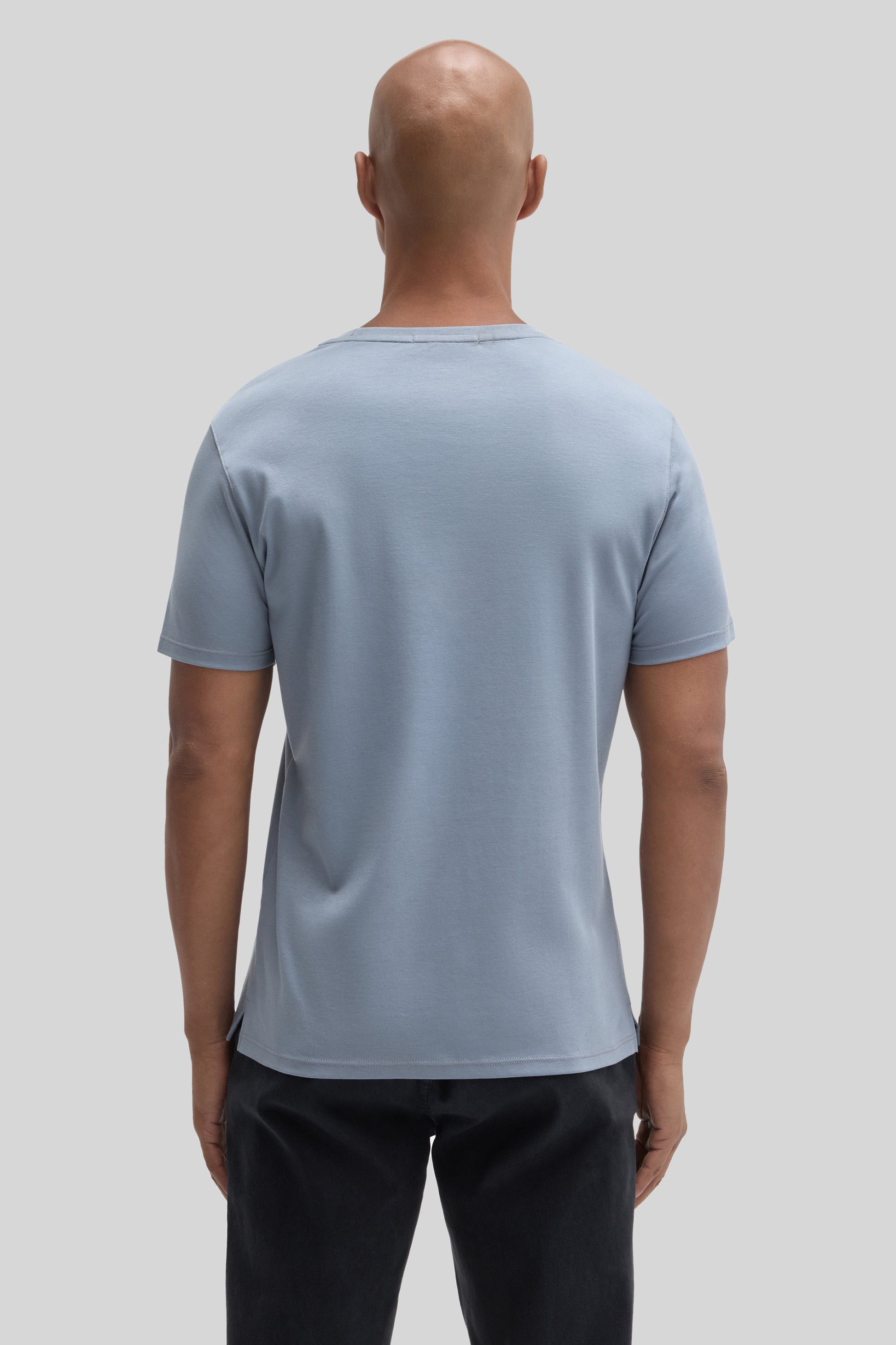 Man wearing light blue short-sleeve t-shirt with crew neckline, shown from back view against neutral background.