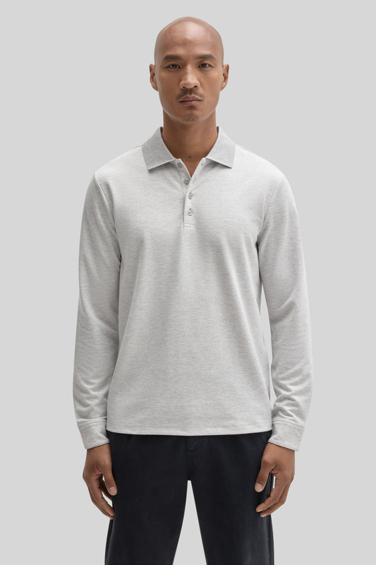 Light gray long sleeve polo shirt with button front and collar, worn with black pants.