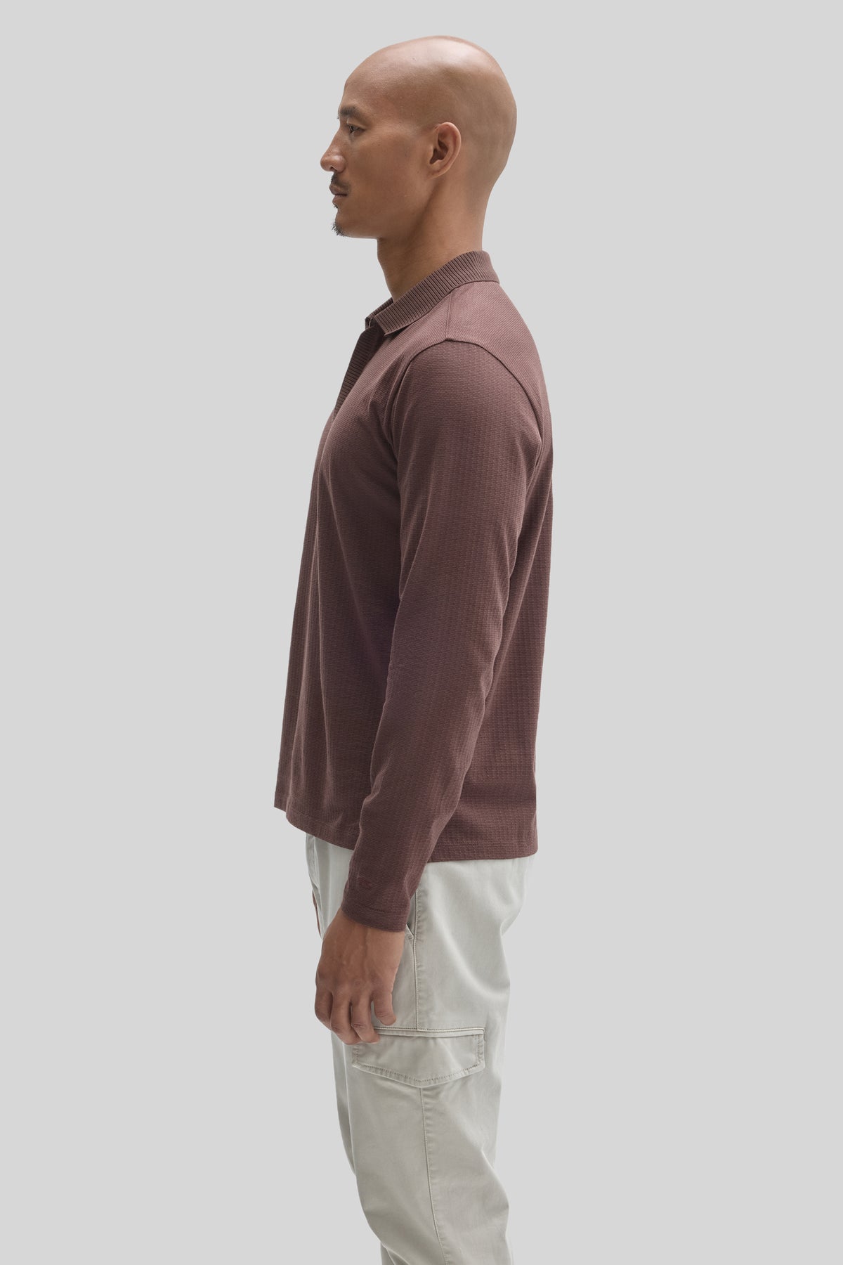 Mauve long-sleeve polo with ribbed collar and placket zip, worn with cream cargo pants.