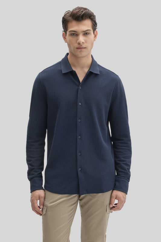Man wearing dark navy long-sleeve button-up knit shirt with textured collar and khaki pants.