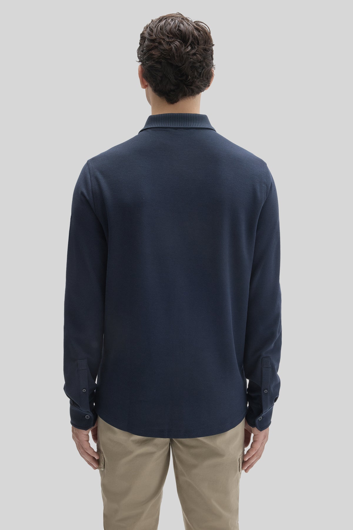 Navy long sleeve knit shirt with ribbed collar and button cuffs, shown from back view.