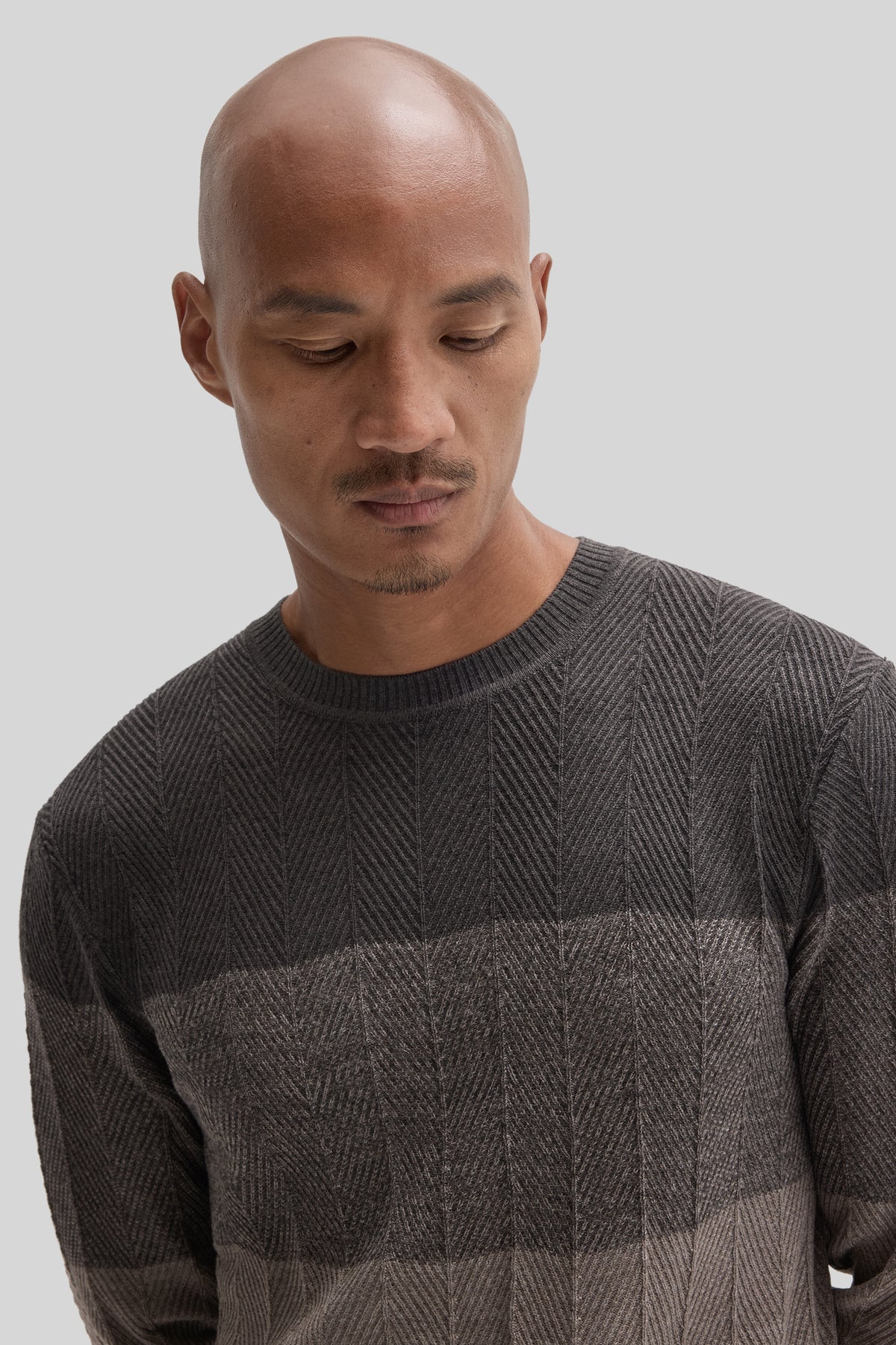 Charcoal crewneck sweater with herringbone pattern, shown on model.