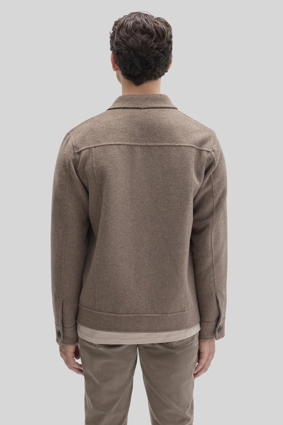 Tan buttoned jacket with collared neckline, shown from back on model wearing neutral pants.