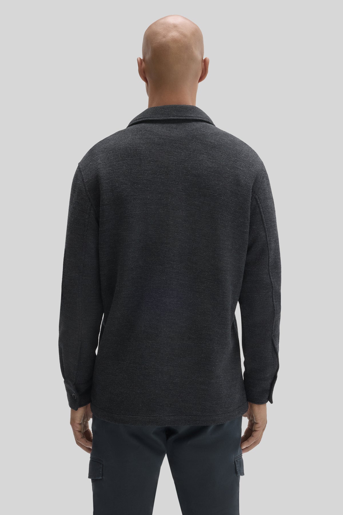 Charcoal gray overshirt with collar, long sleeves, and button cuffs, worn over dark pants, shown from back.
