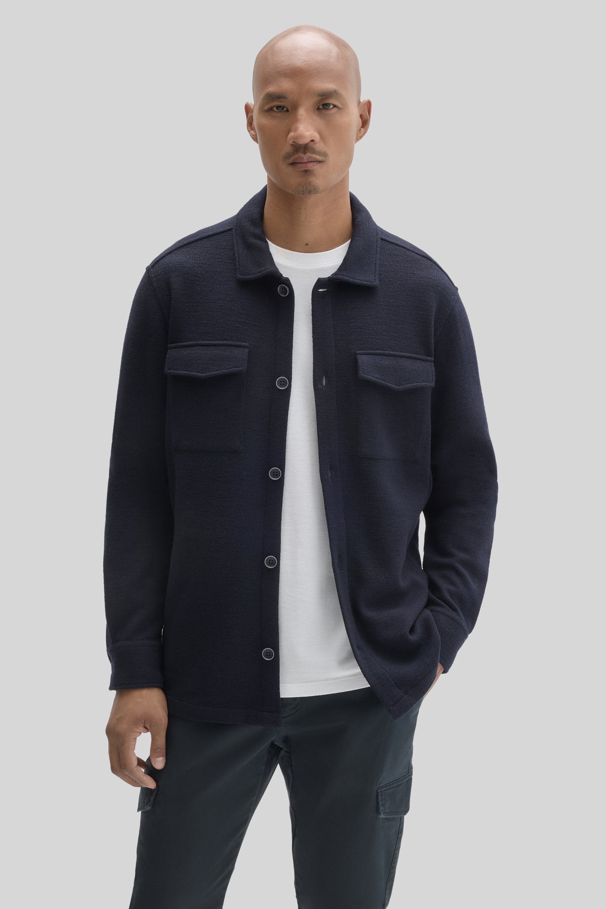 Navy overshirt with collar, button front, chest pockets, and long sleeves worn over white t-shirt.