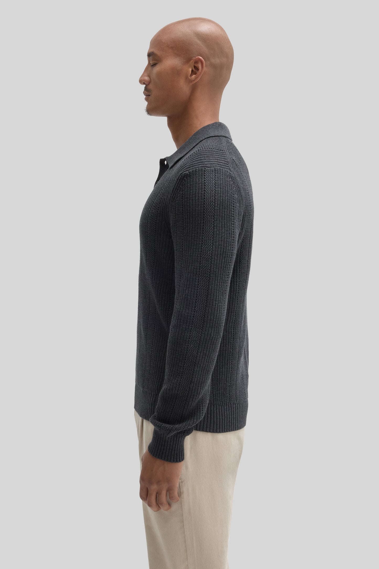 Charcoal ribbed knit polo sweater with collar, shown on model wearing cream pants.