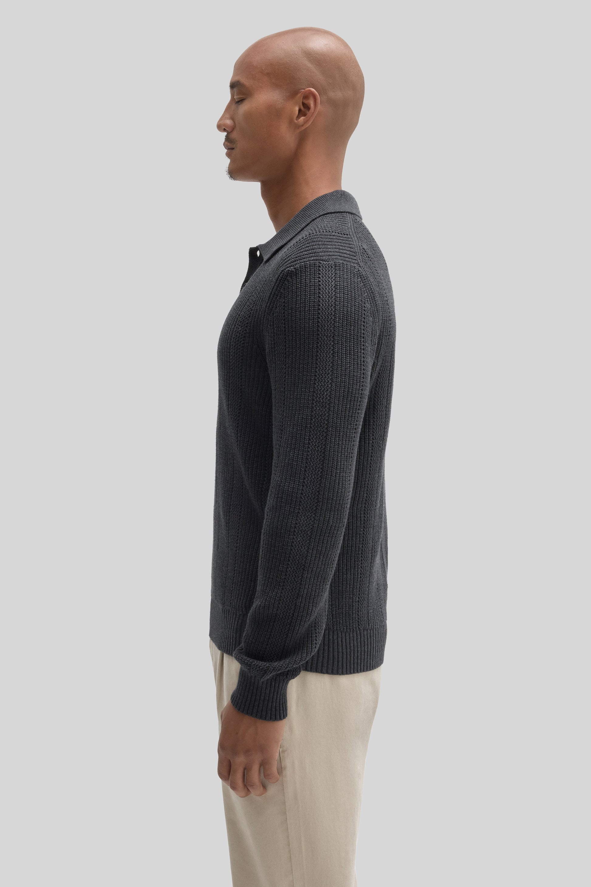 Charcoal ribbed knit polo sweater with collar, shown on model wearing cream pants.