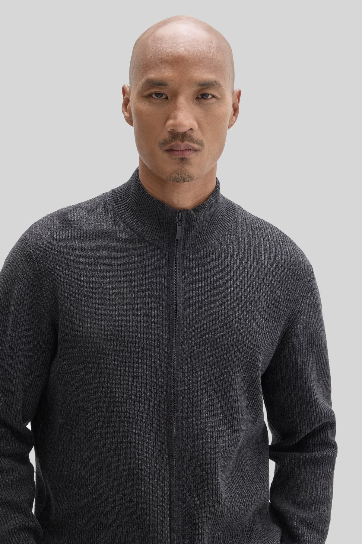 Charcoal gray ribbed mock neck sweater with full-length front zipper on model.