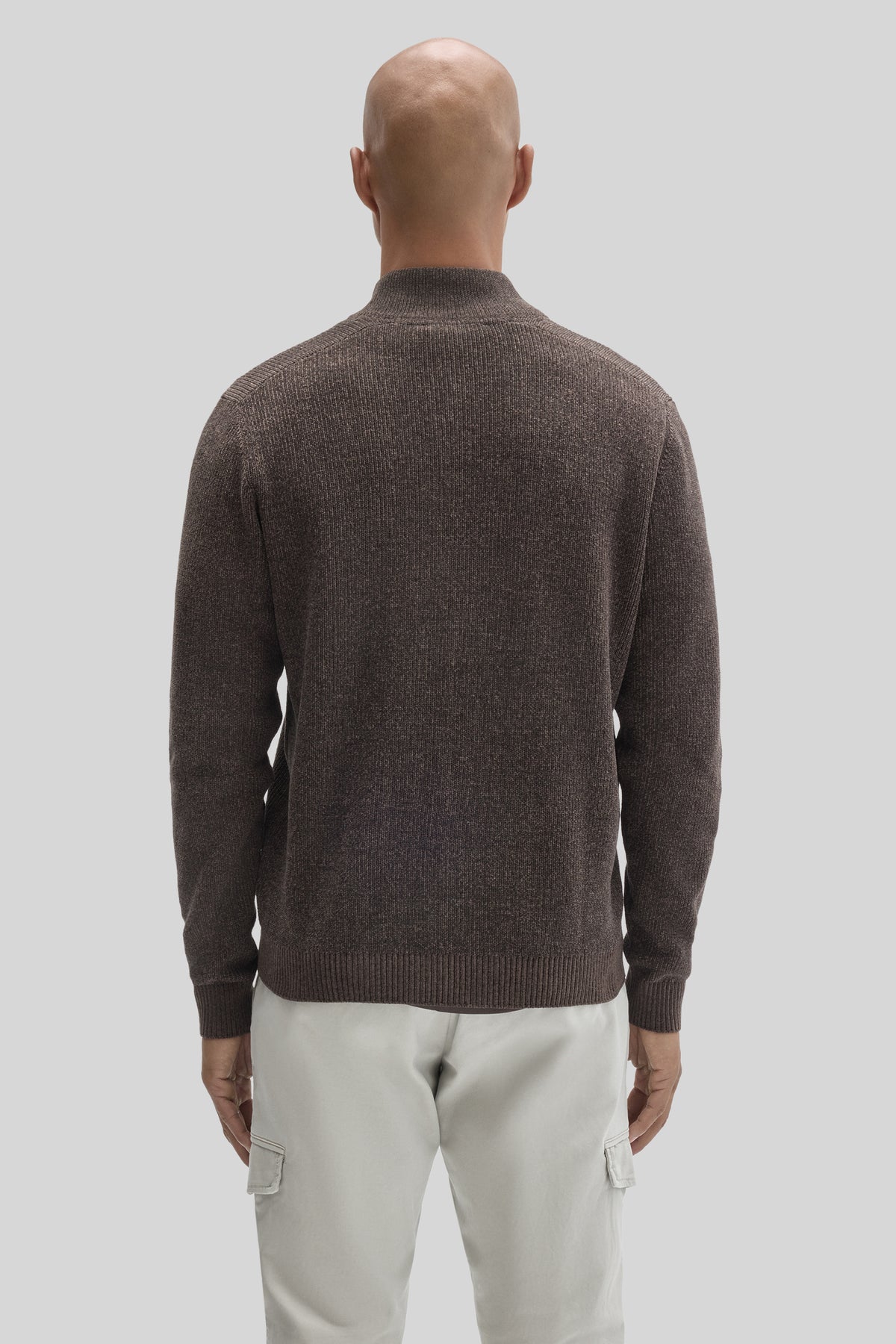 Charcoal gray ribbed mock neck sweater with full zip, shown from back on model wearing cream cargo pants.