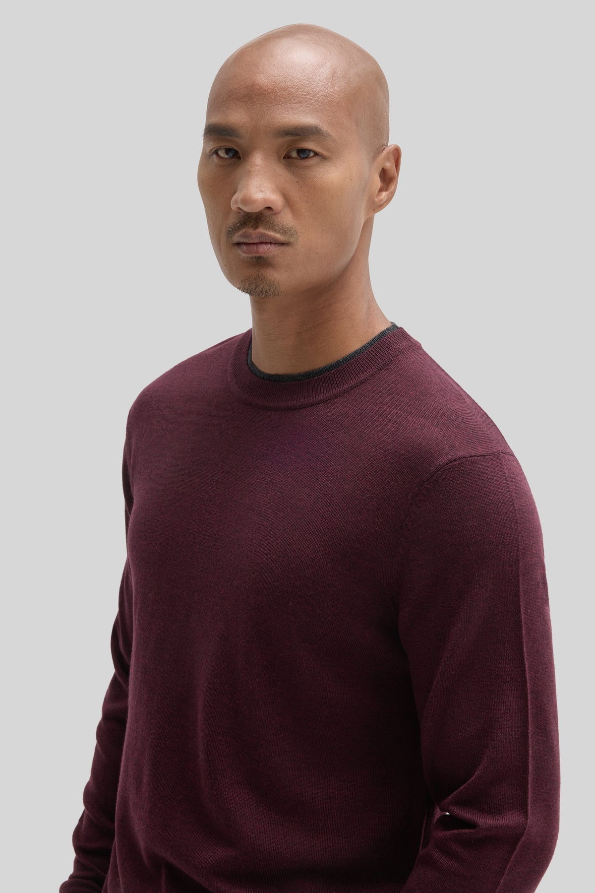 Burgundy crewneck sweater with ribbed neckline and cuffs on a male model.