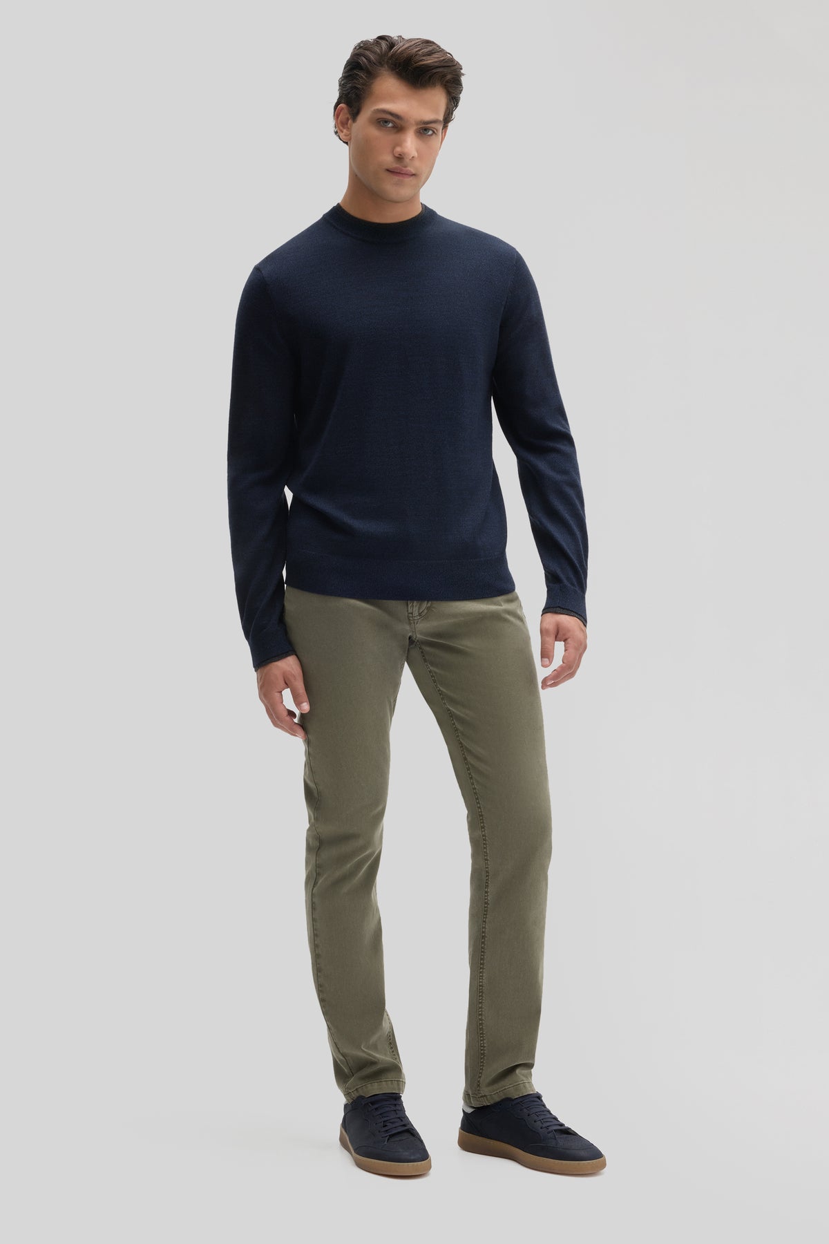 Man wearing dark navy crewneck sweater with long sleeves and khaki pants.
