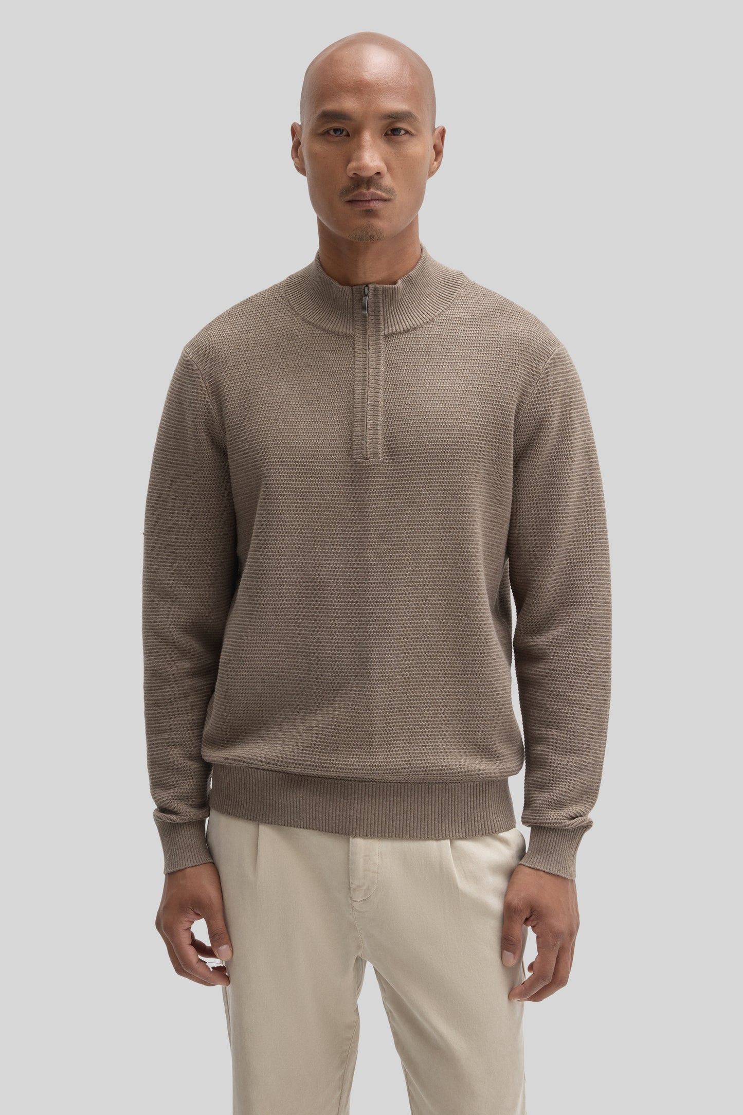 Beige quarter zip sweater with ribbed texture worn with cream pants.