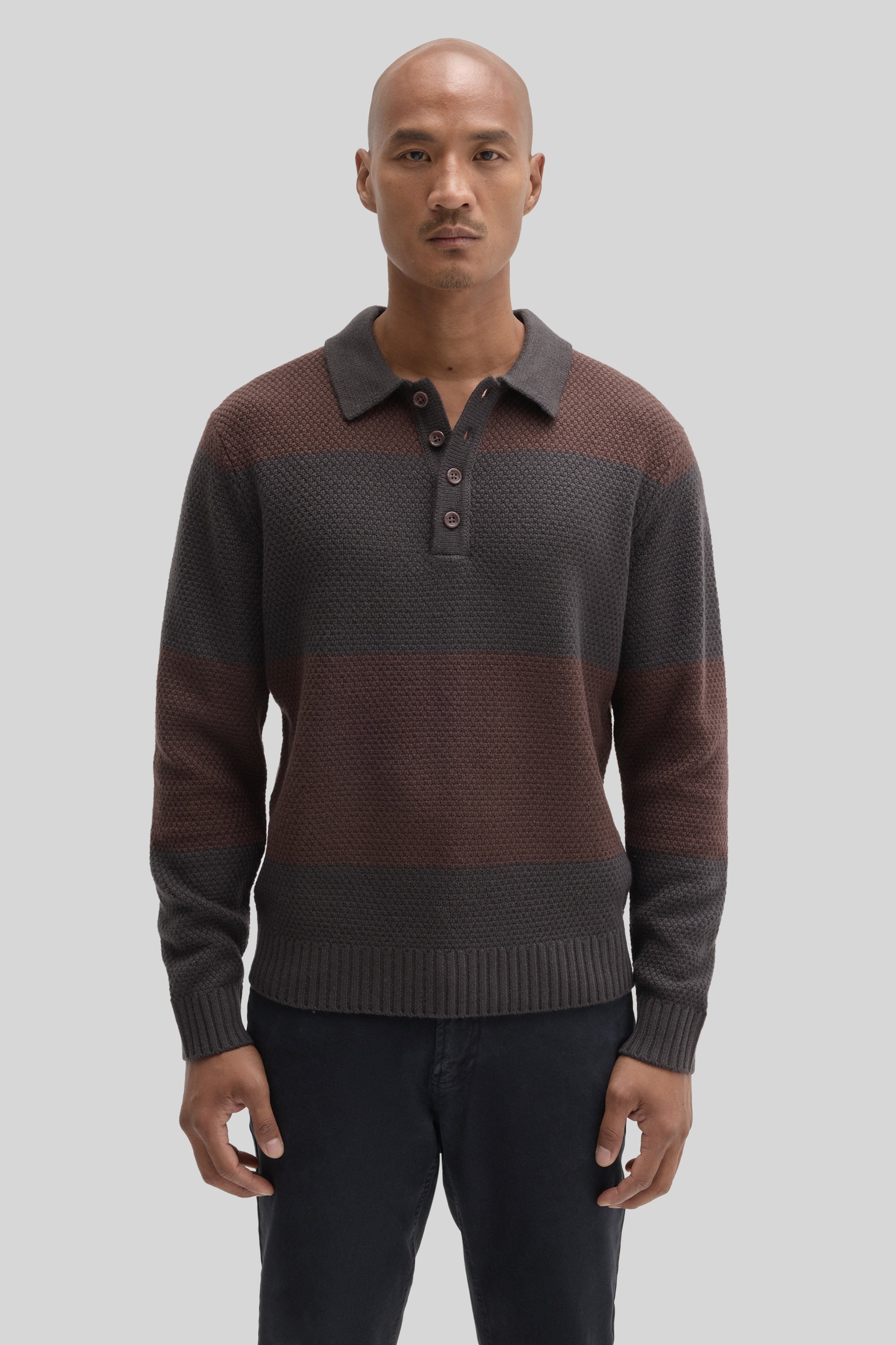 Men's rugby polo sweater in charcoal and burgundy color-block knit with collar and button placket.