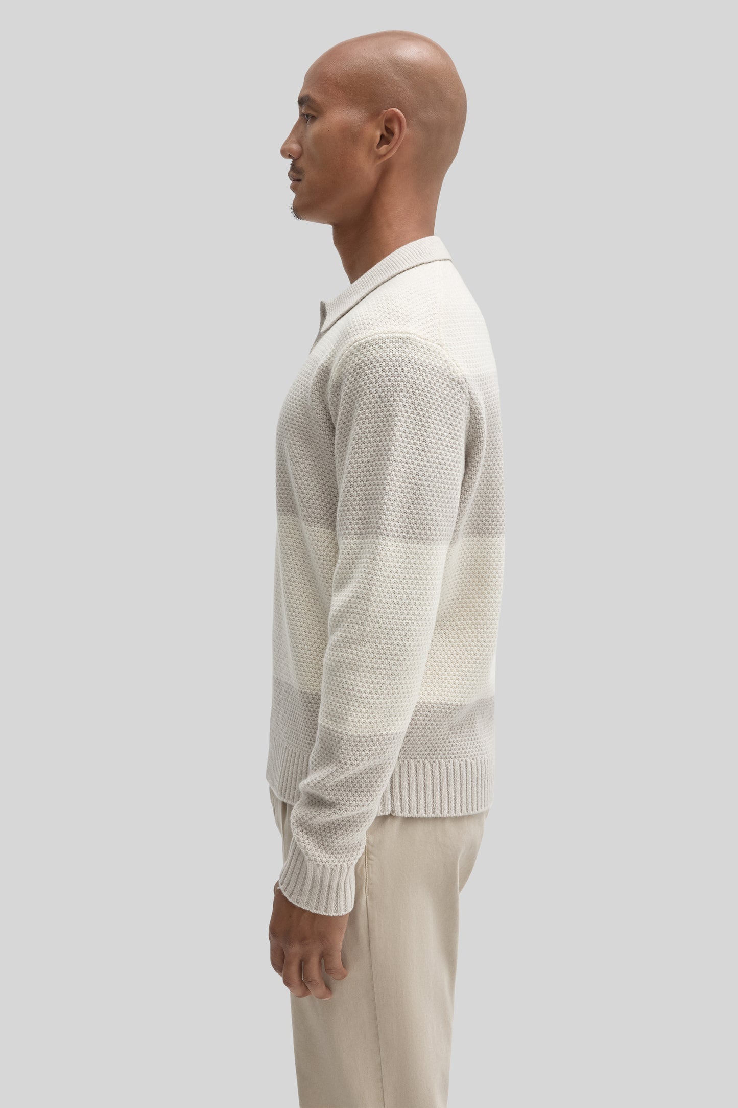 Cream-colored rugby polo sweater with textured knit pattern and ribbed collar, cuffs, and hem worn by male model.