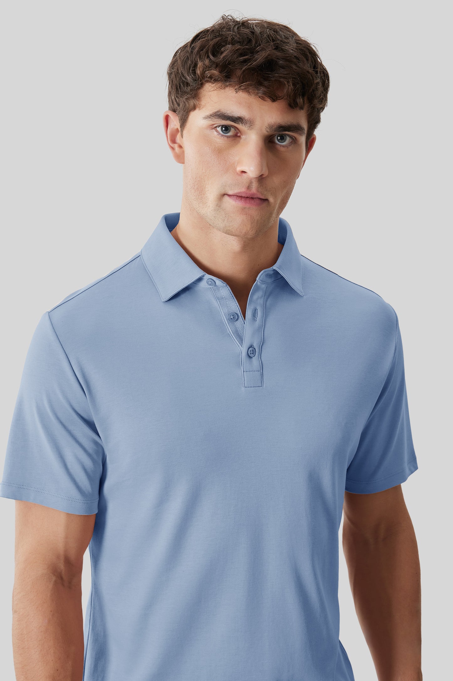 Light blue polo shirt with herringbone pattern on collar and short sleeves, worn by man against neutral background.
