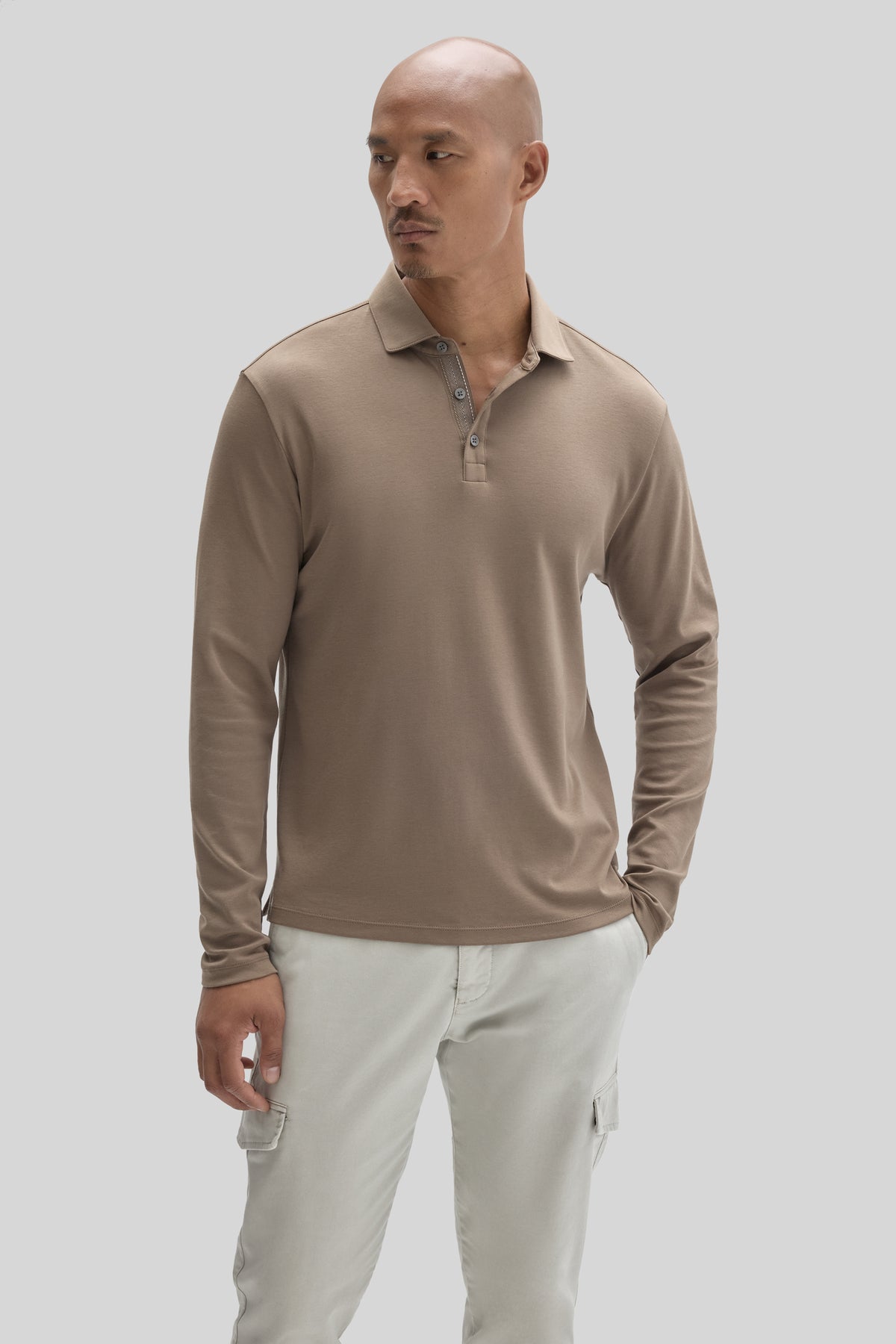 Beige long-sleeve polo shirt with herringbone texture and button placket worn with cream cargo pants.