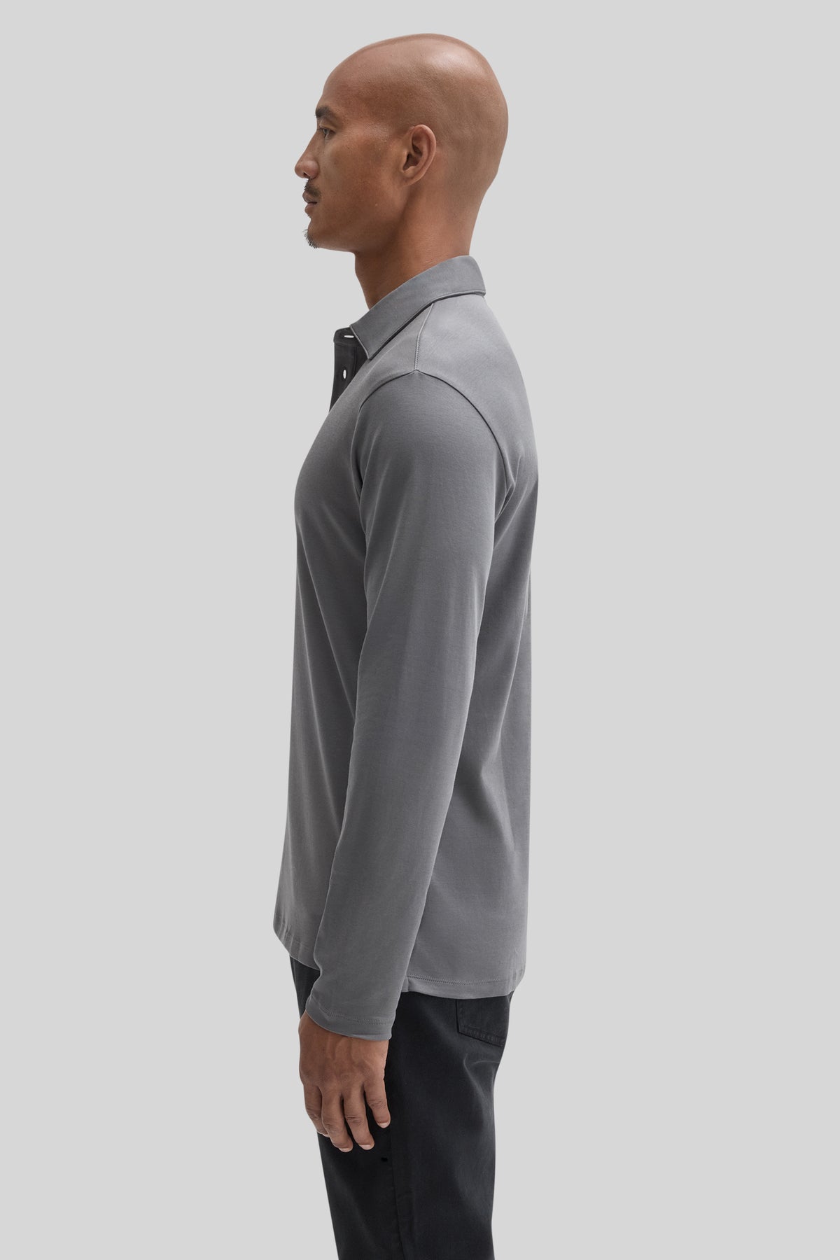 Gray long-sleeve polo shirt with herringbone texture worn with black pants.