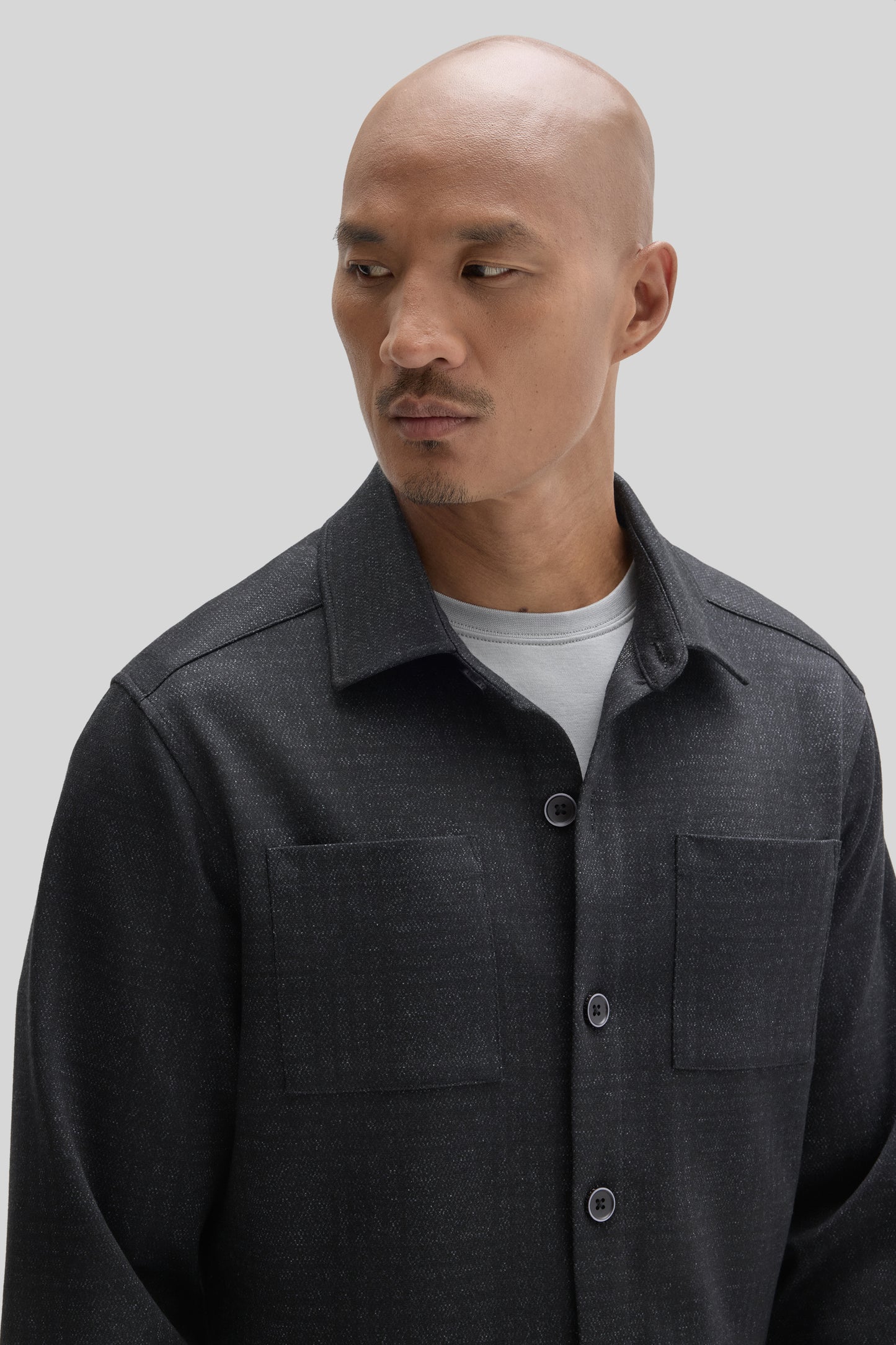 Man wearing charcoal gray Upton Overshirt with collar and button front over white t-shirt.