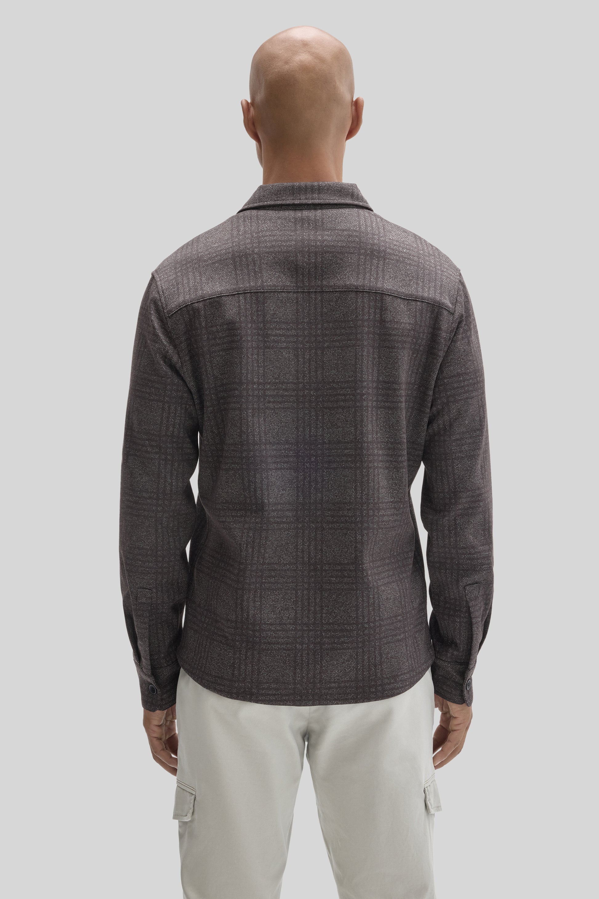 Charcoal gray plaid overshirt with collar, worn over cream cargo pants, shown from back view.