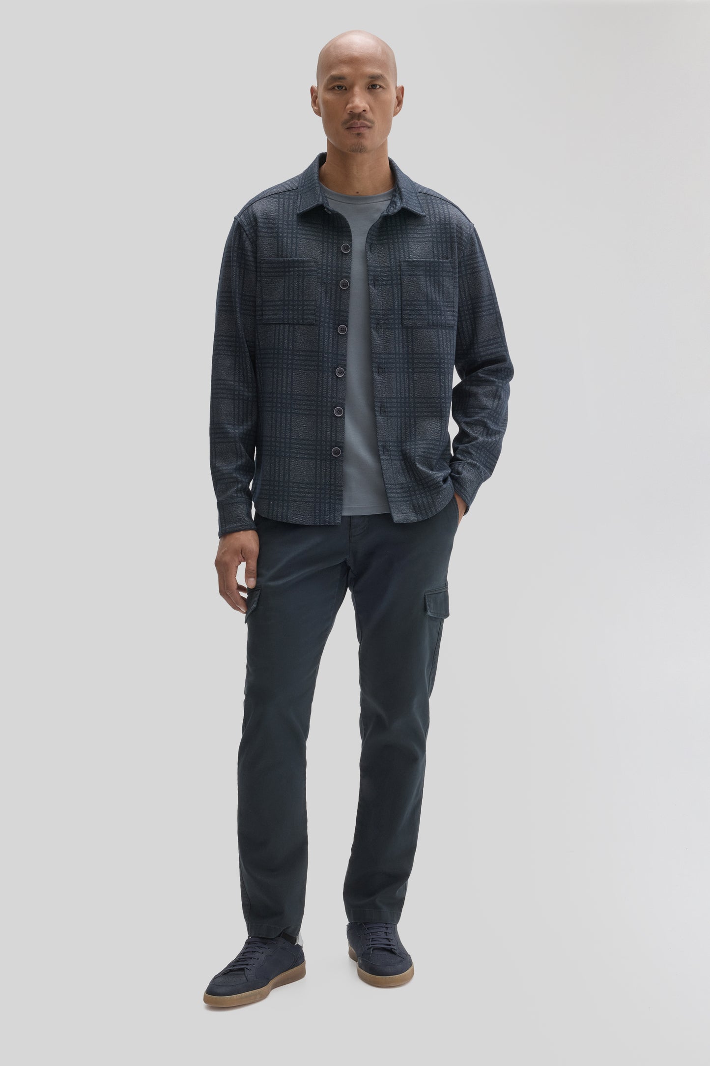 Navy plaid overshirt with button front and chest pockets worn over gray t-shirt and black cargo pants.