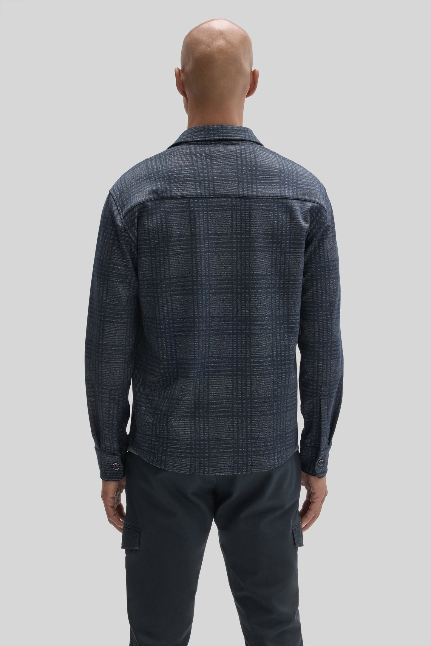 Navy plaid overshirt with long sleeves and collar, shown from back on model wearing black cargo pants.